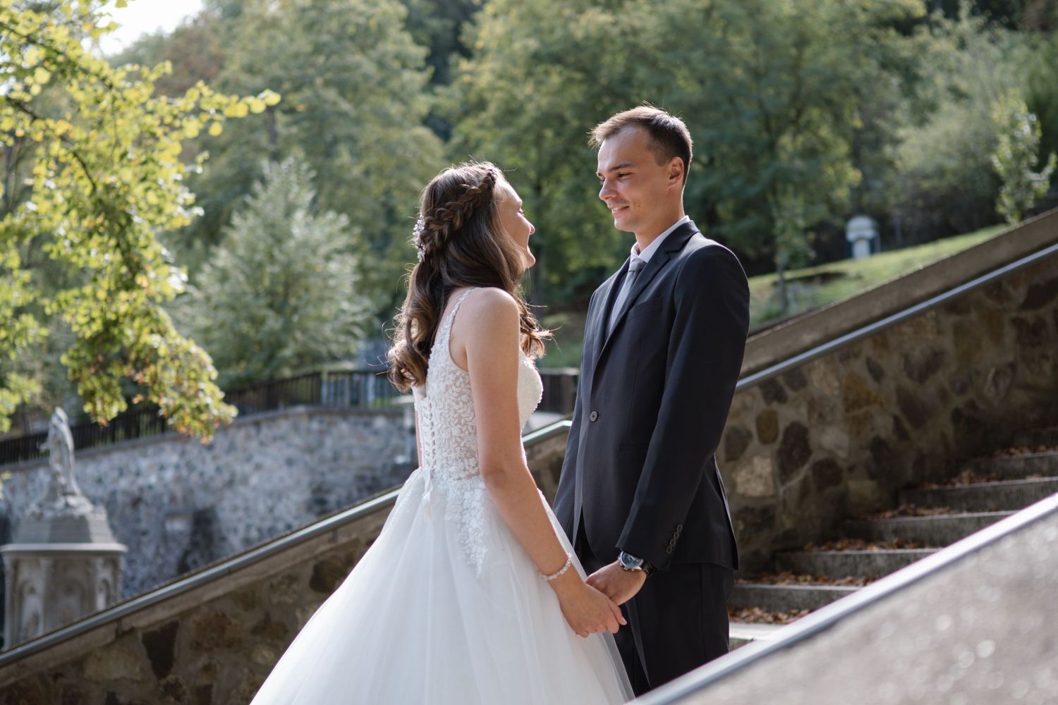 A couple shares an intimate moment on stone steps during their outdoor wedding photoshoot.