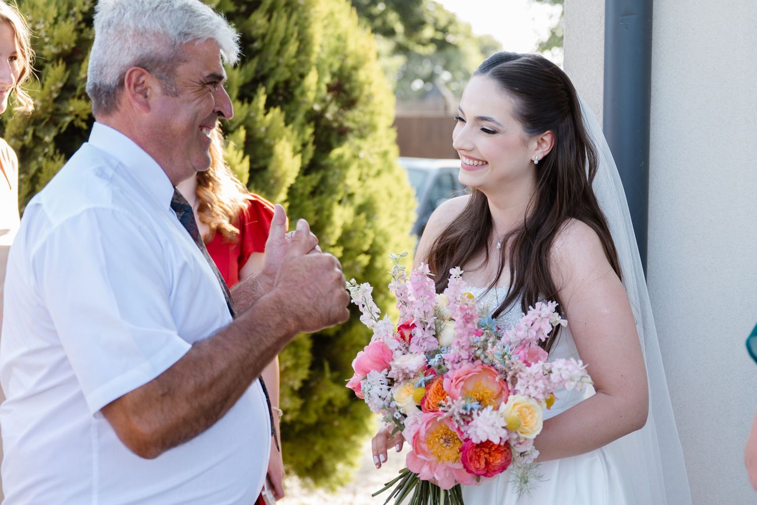 A joyful outdoor wedding moment captured with colorful floral bouquets.