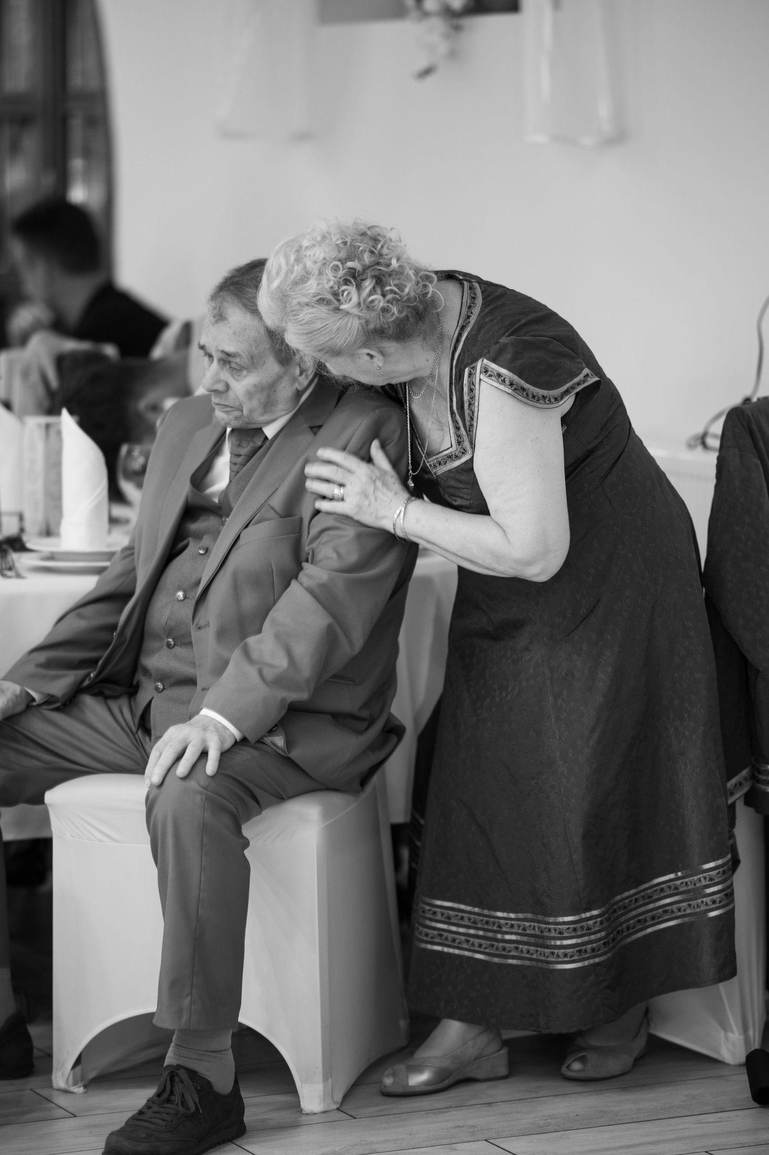 Black and white photo of elderly guests resting during a wedding reception.