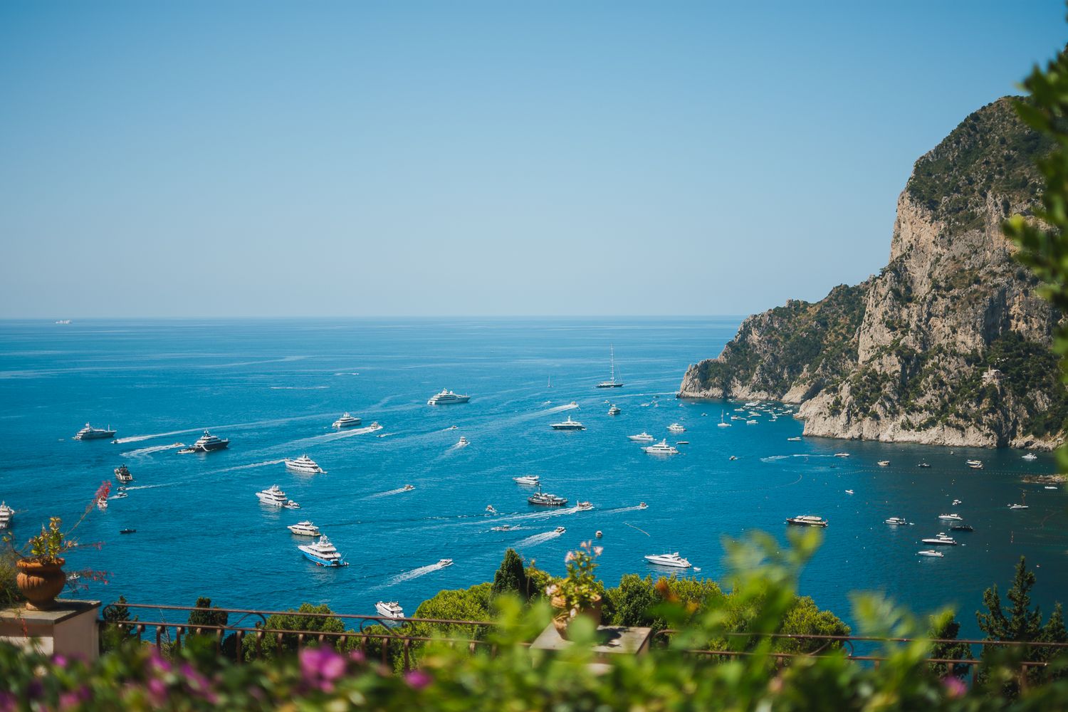 Beautiful coastal panorama showing blue Mediterranean waters and boats dotting the bay.