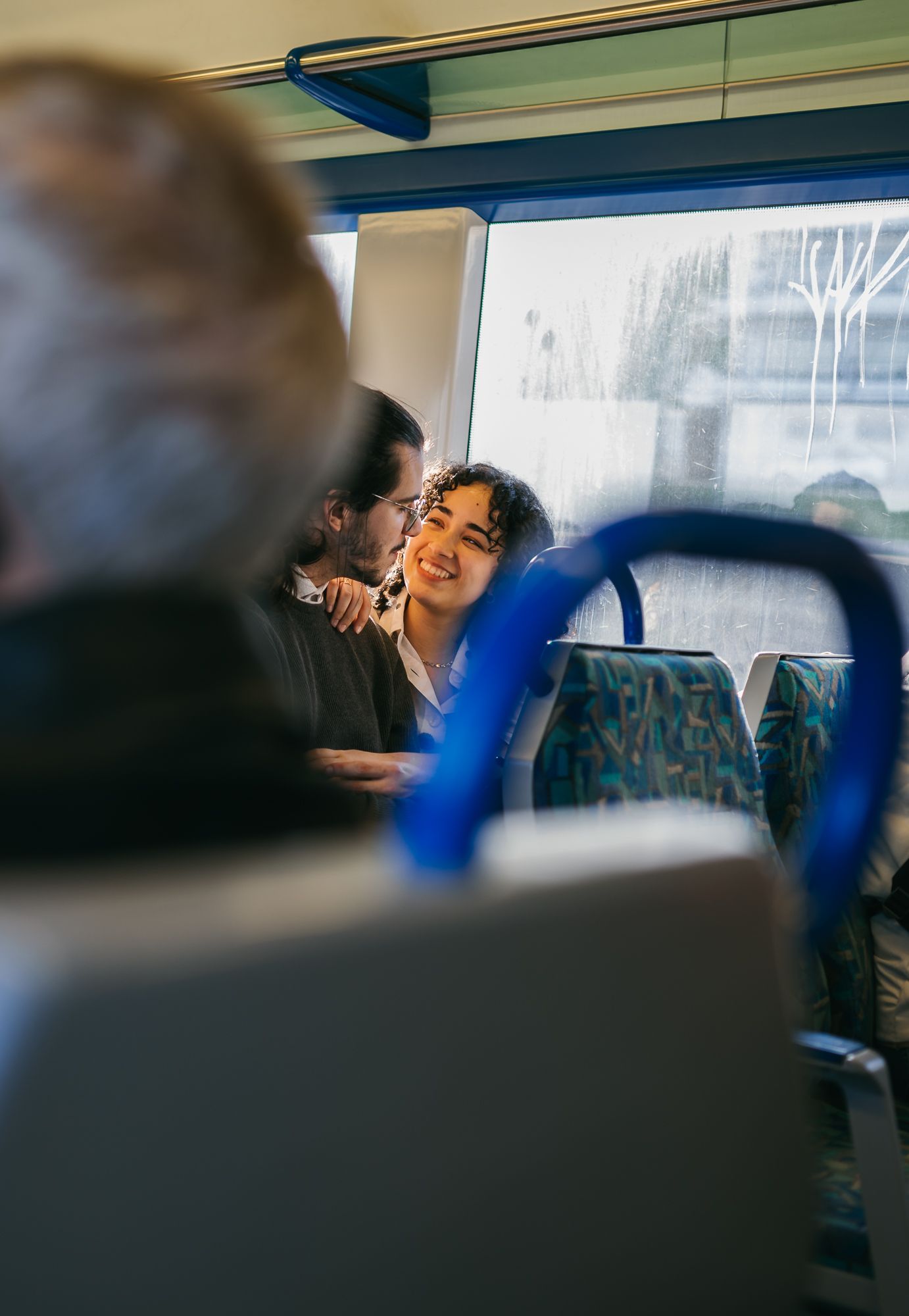 People enjoying a playful moment during a train journey with motion blur and laughter.