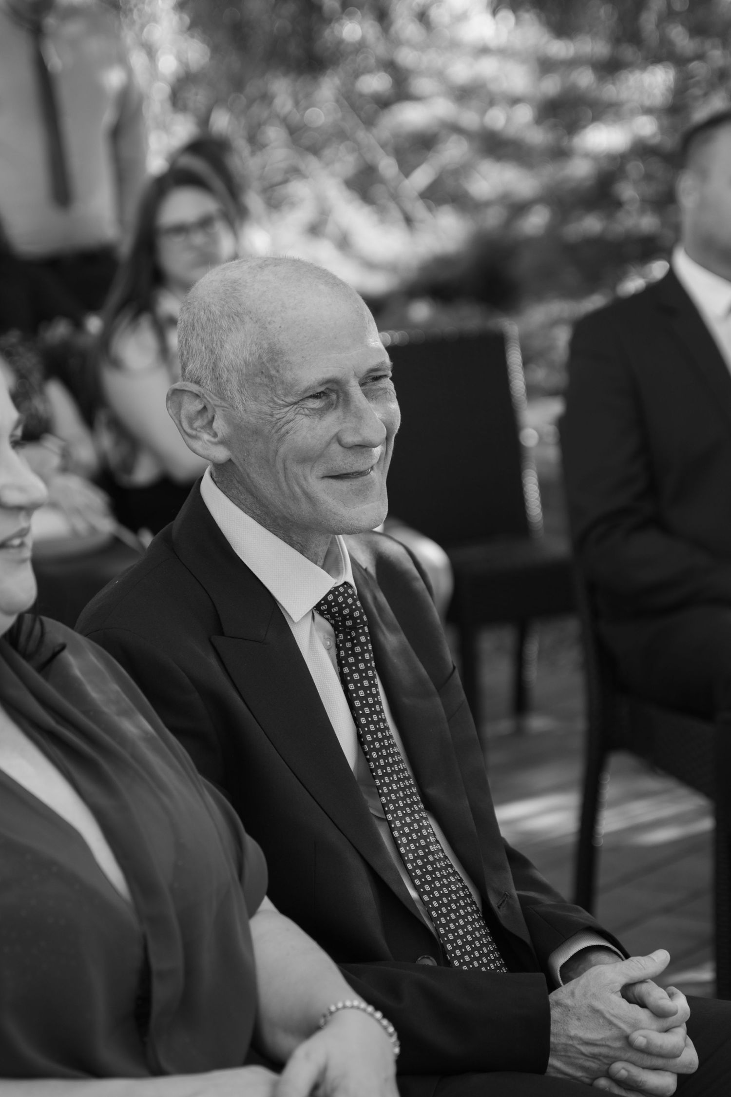 Black and white portraits of guests at an outdoor wedding ceremony.