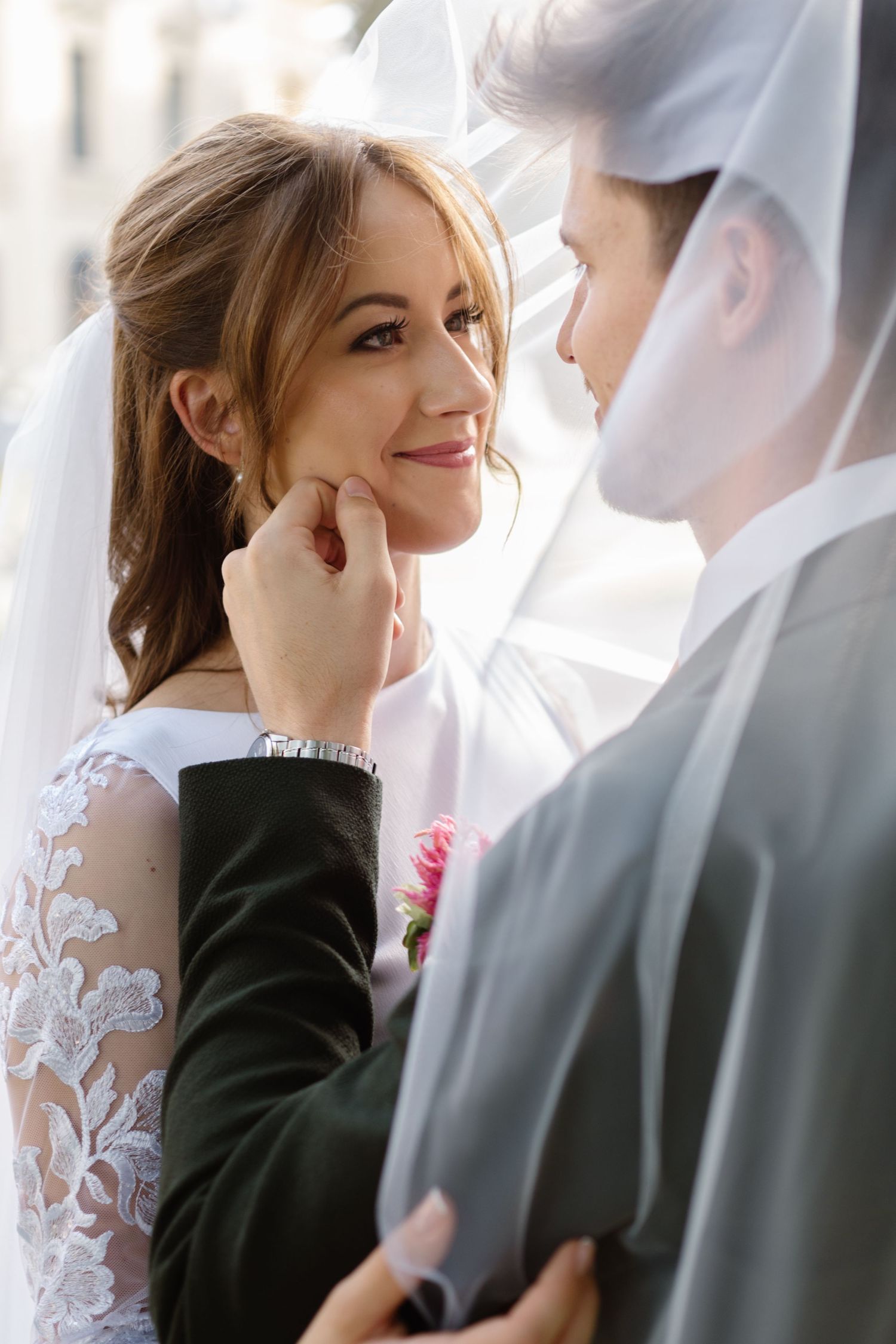 A tender moment between a couple in wedding attire with soft lighting.