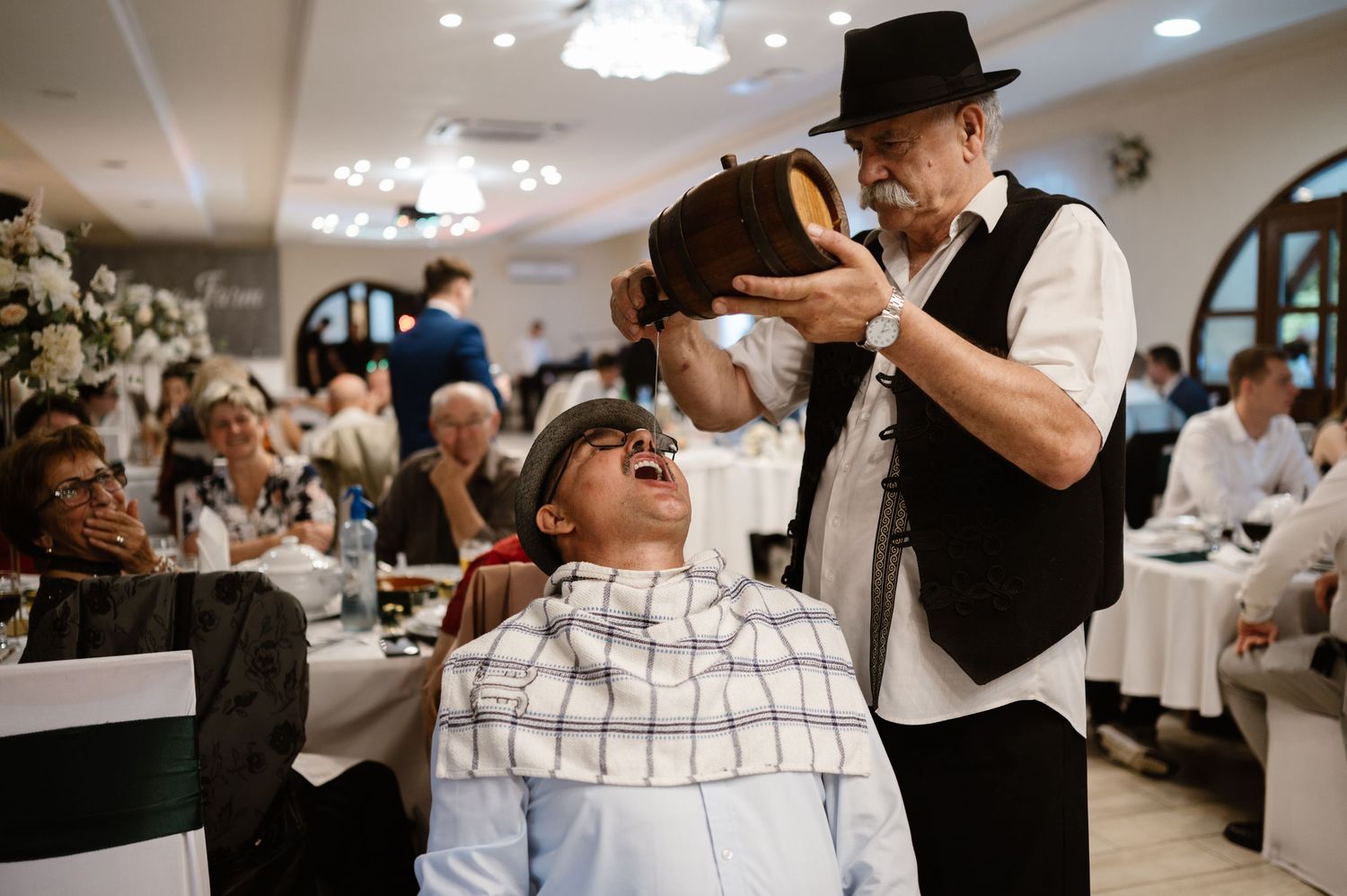 Wedding reception guests toast and celebrate in an elegant indoor venue.