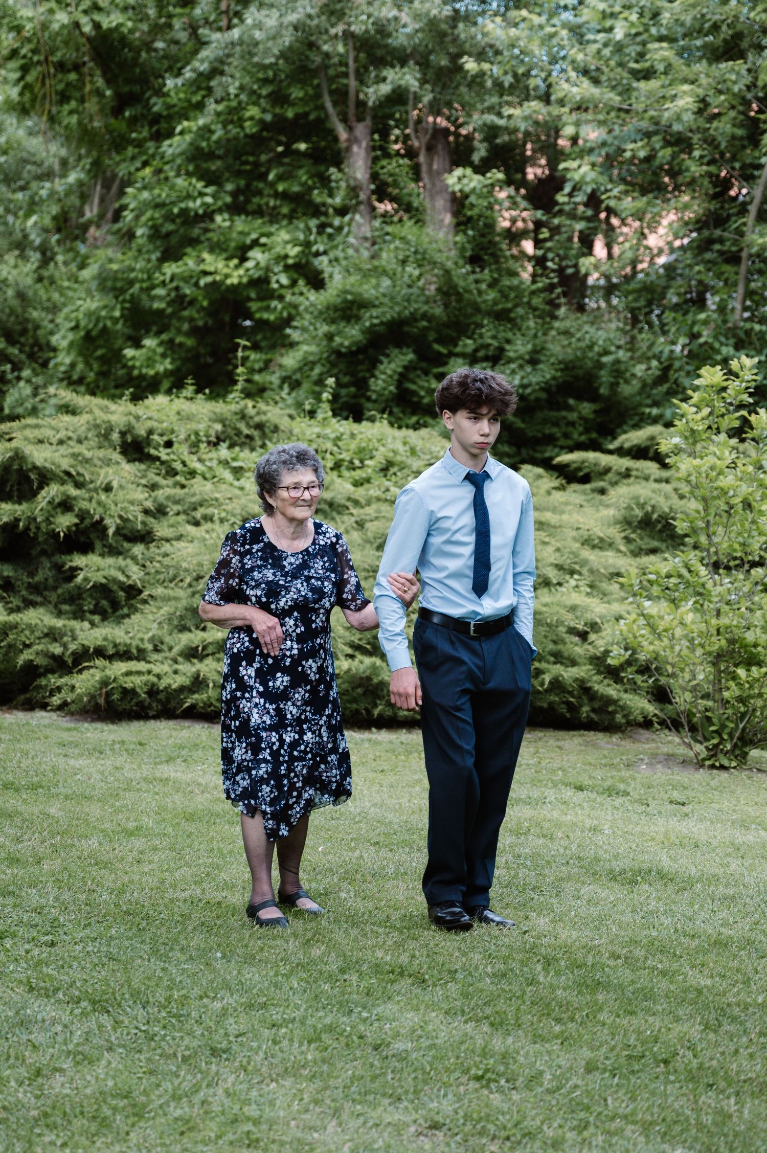 Candid moment captured in a lush green garden setting during an event.