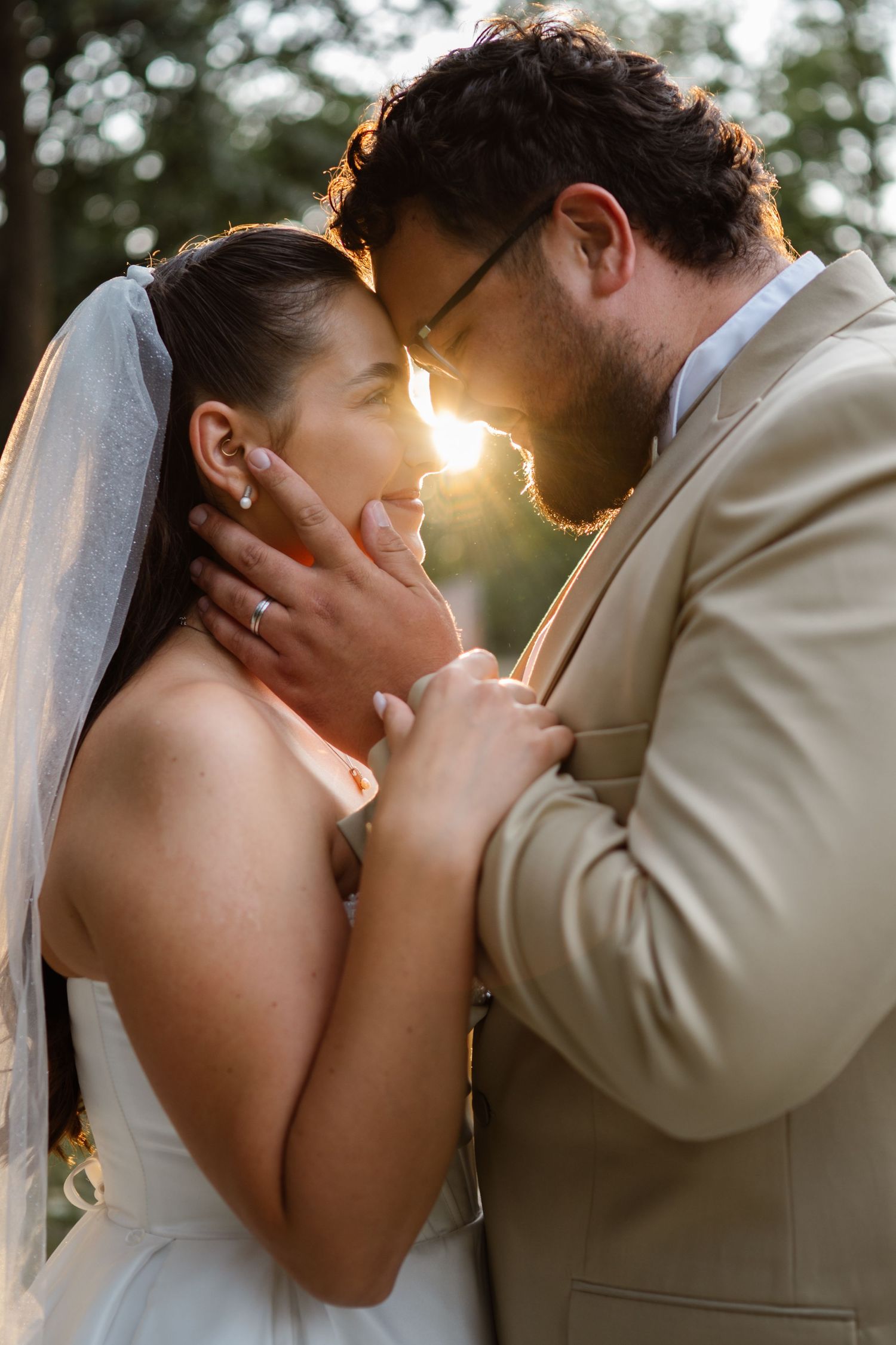 Romantic sunset wedding portraits with golden backlighting creating a dreamy atmosphere.