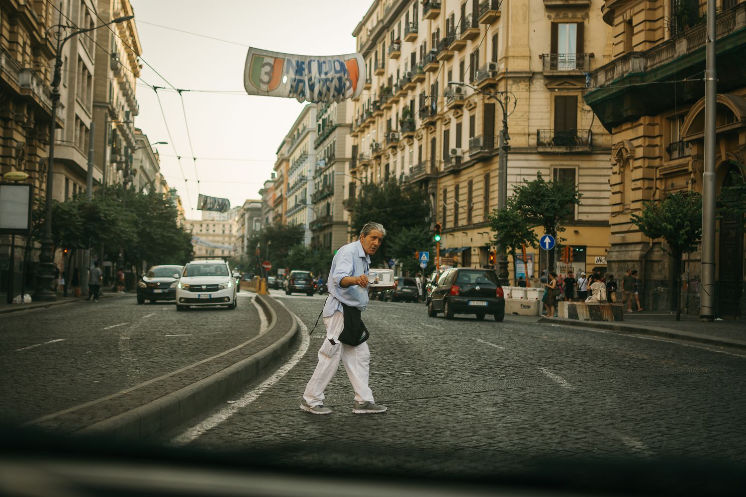 Urban street scene with historic buildings and cobblestone roads in an Italian city.