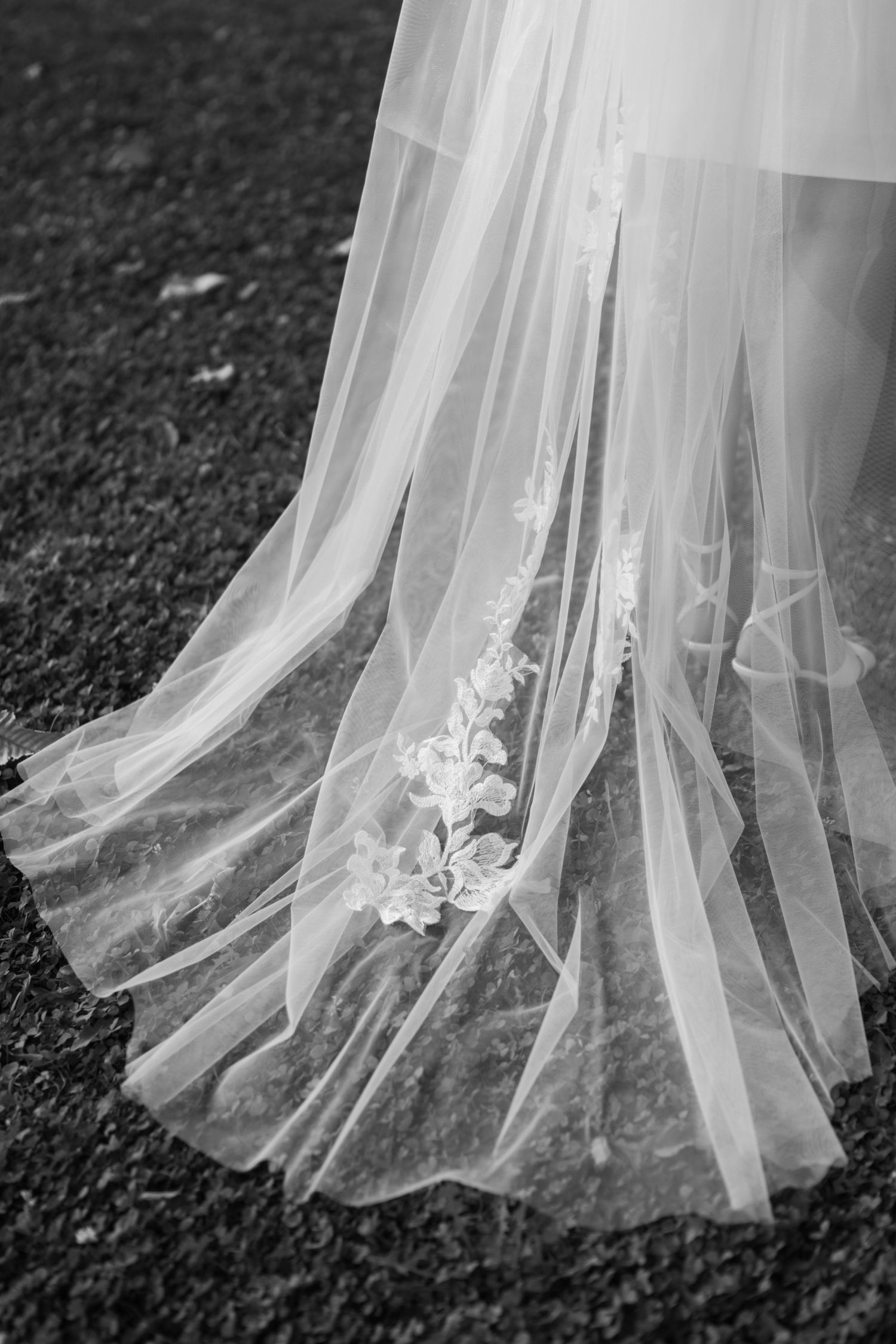 Detail shots of delicate lace and embroidery on flowing white wedding dress hem.