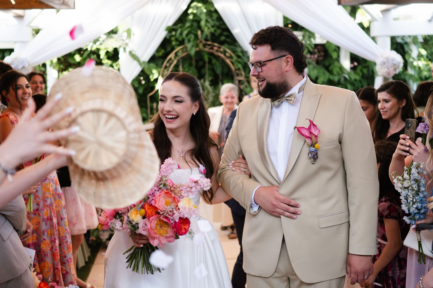 Wedding celebration in an outdoor garden setting with tropical floral decorations.