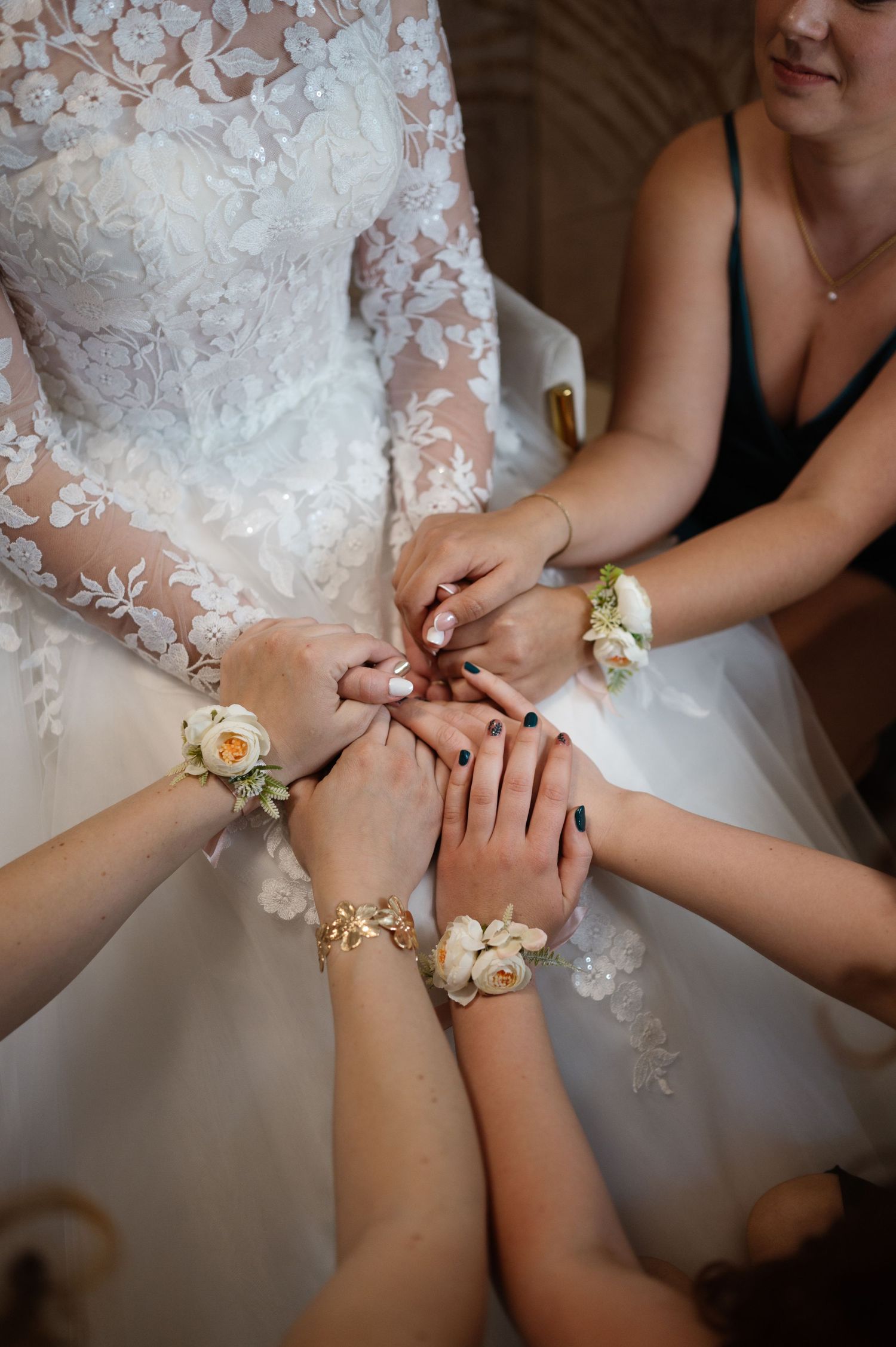 Close-up of hands putting on delicate floral corsages during wedding preparations.