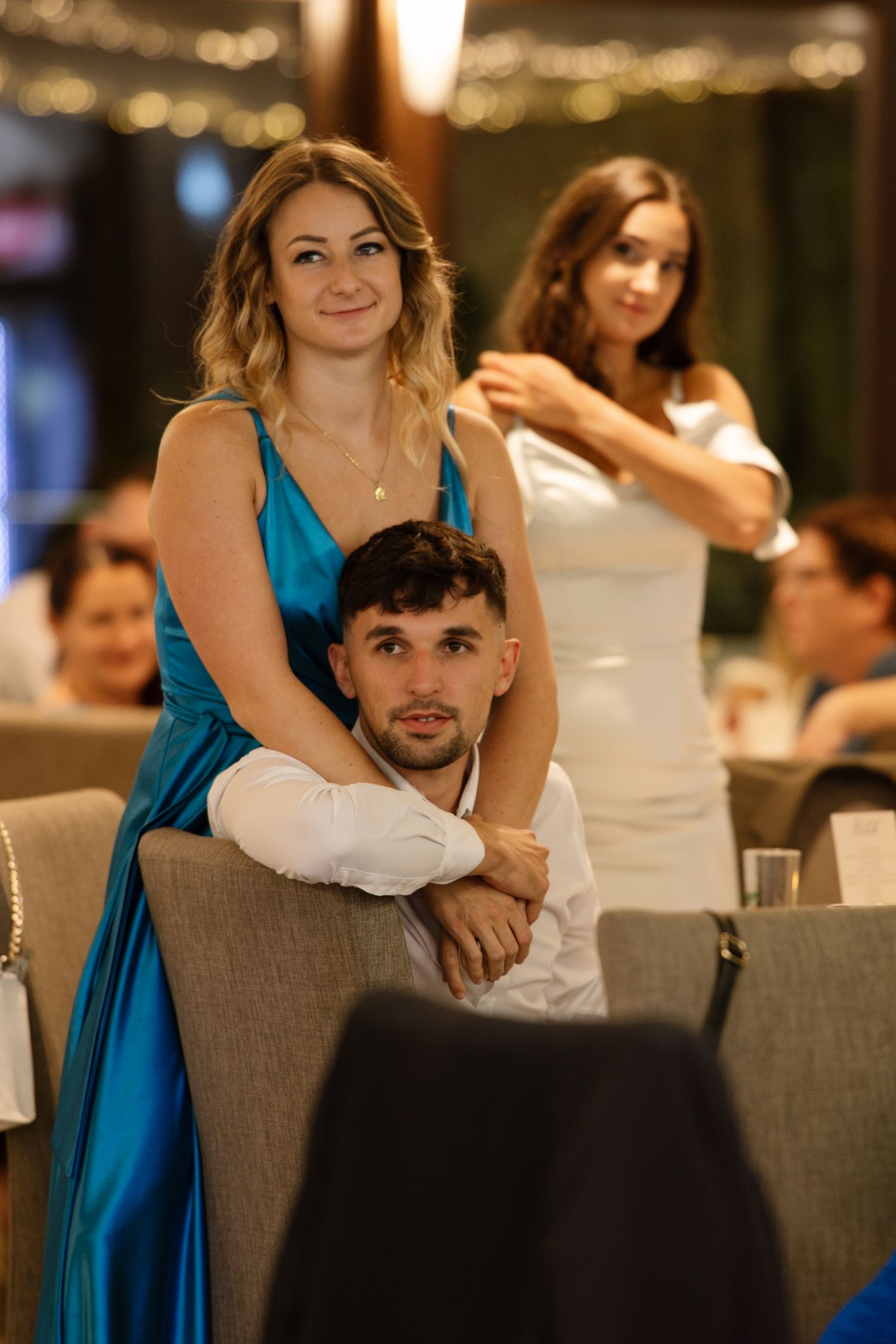 Wedding reception guests relaxing at tables decorated with ambient lighting.