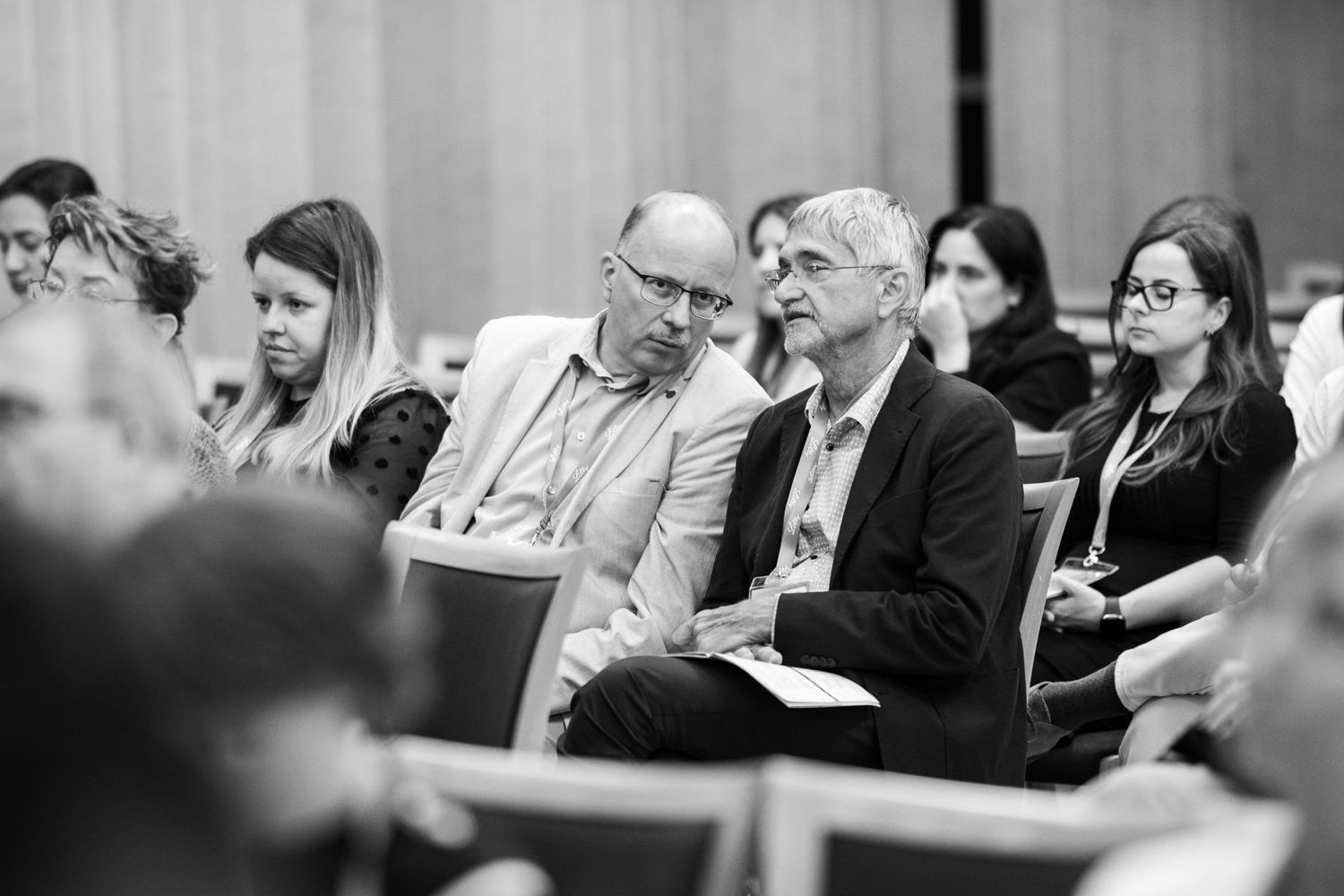 Business professionals engaged in discussion during a professional meeting or conference in black and white.