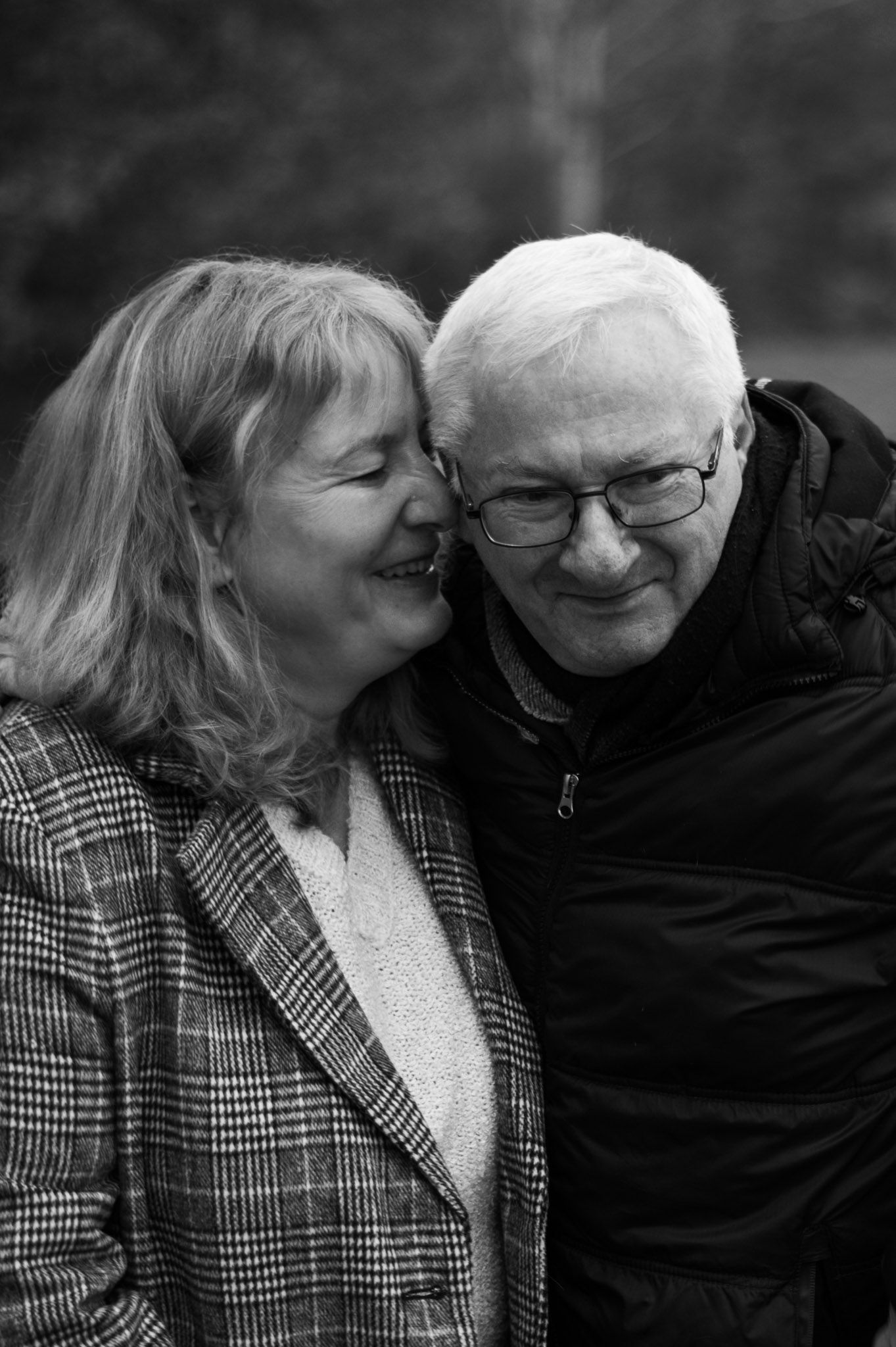 An intimate black and white portrait of a mature couple sharing a tender moment together.