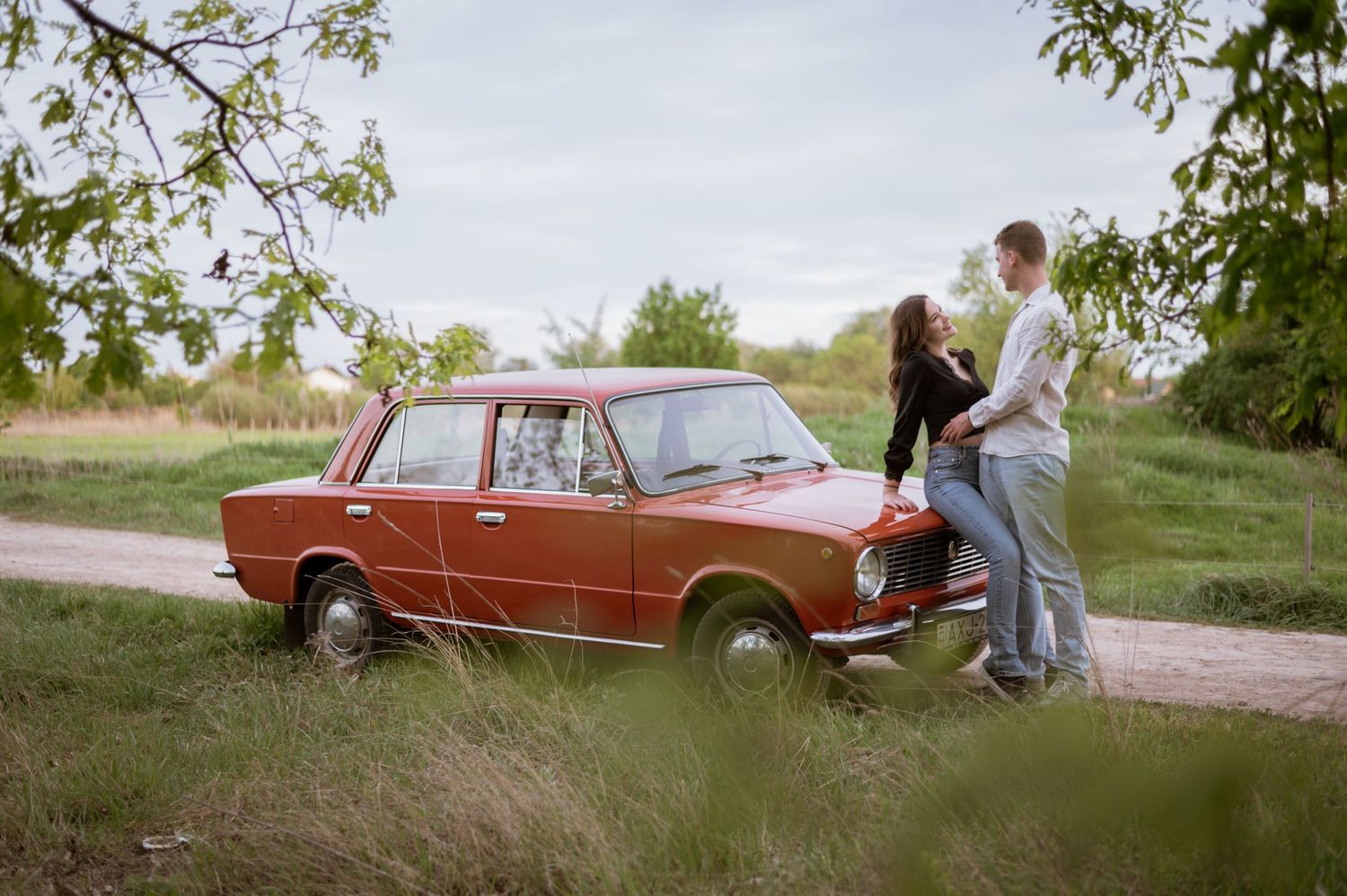 Vintage car photoshoot sequence in a rustic outdoor setting.