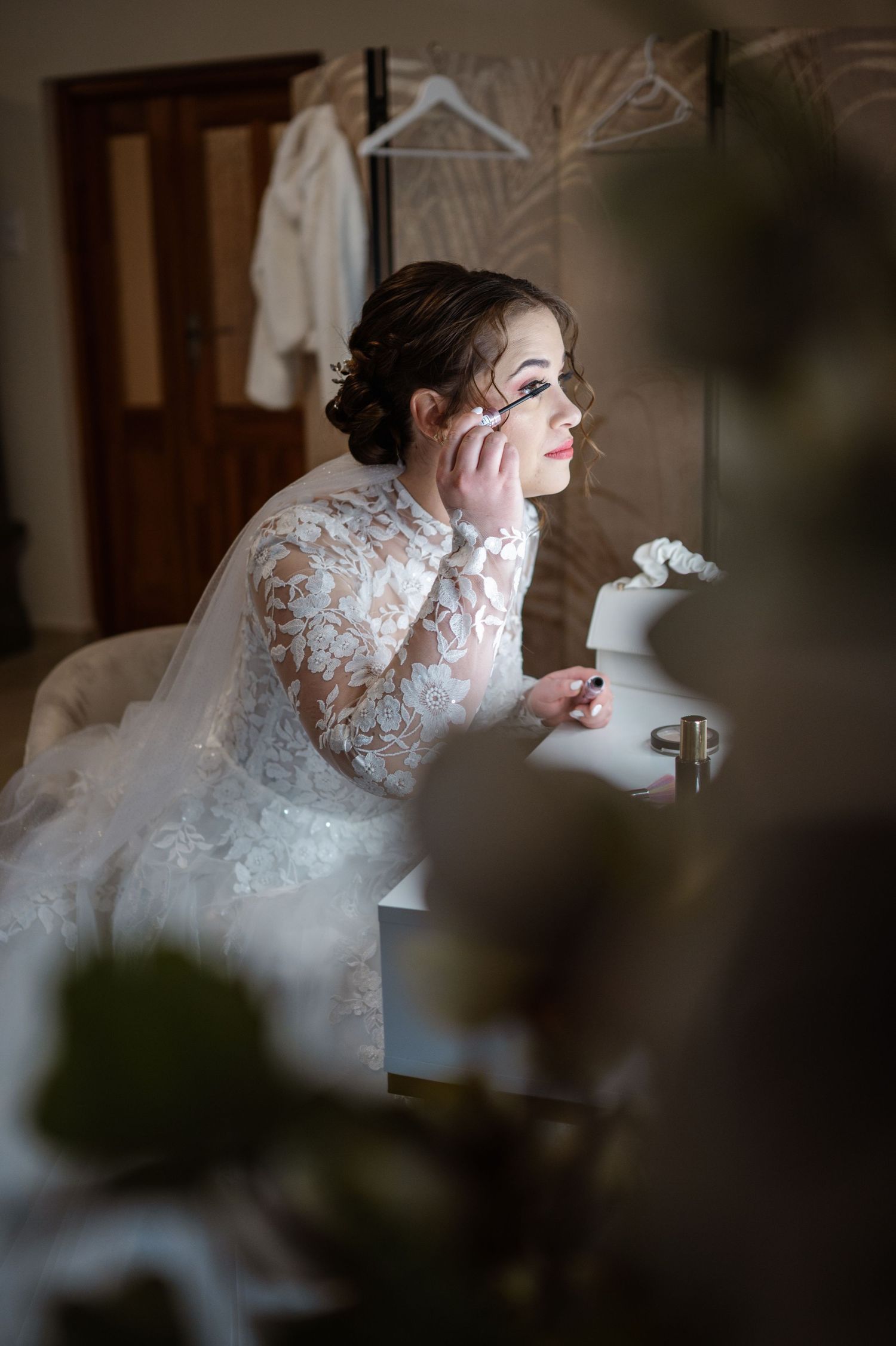 Artistic portrait of a bride getting ready in soft natural light.