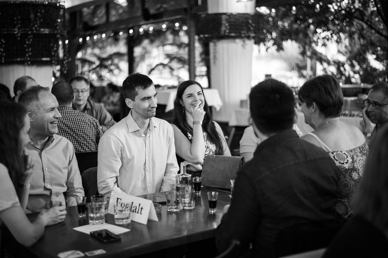 Black and white photo of attendees mingling at a social gathering.