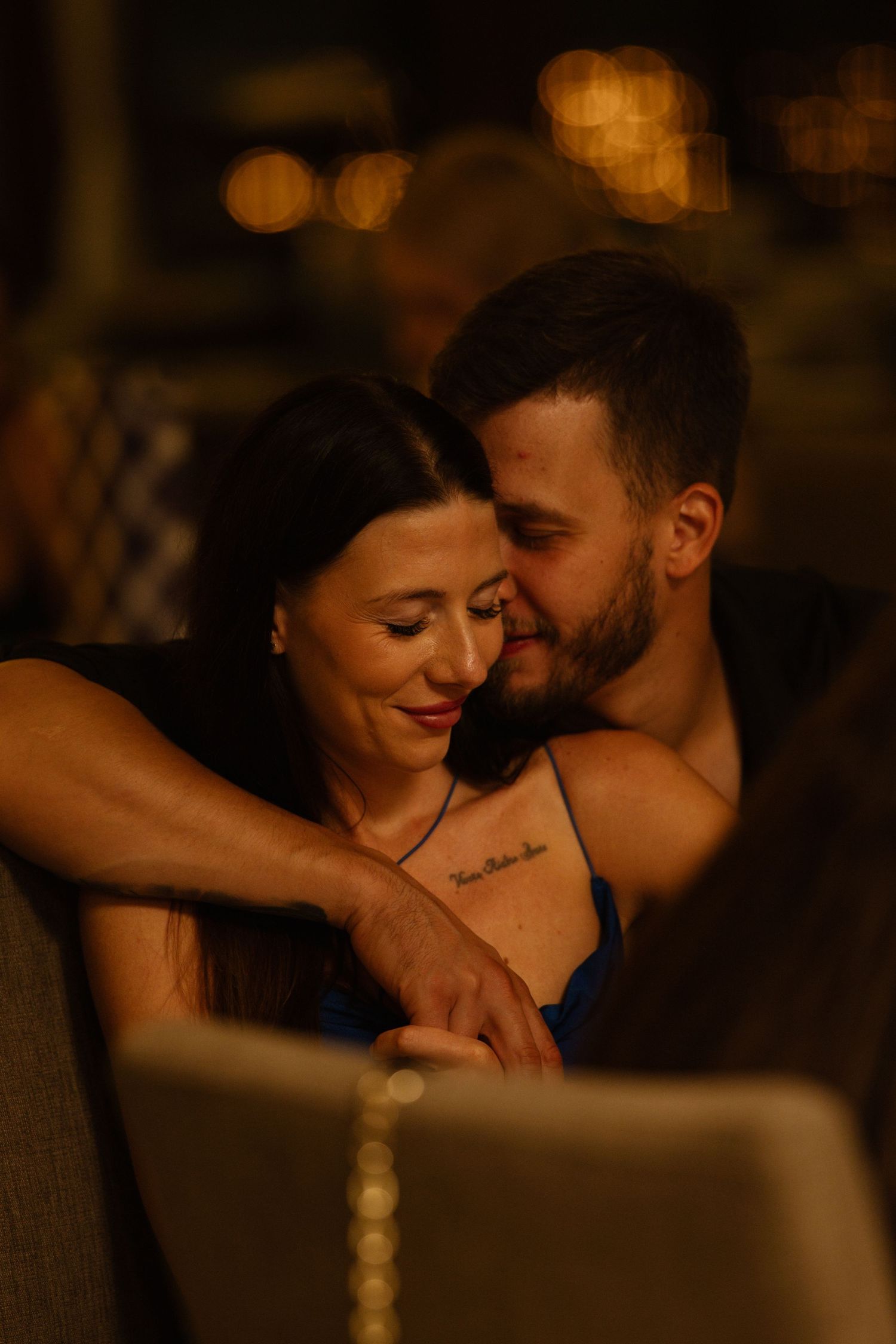 Intimate romantic moment captured in warm candlelit setting.