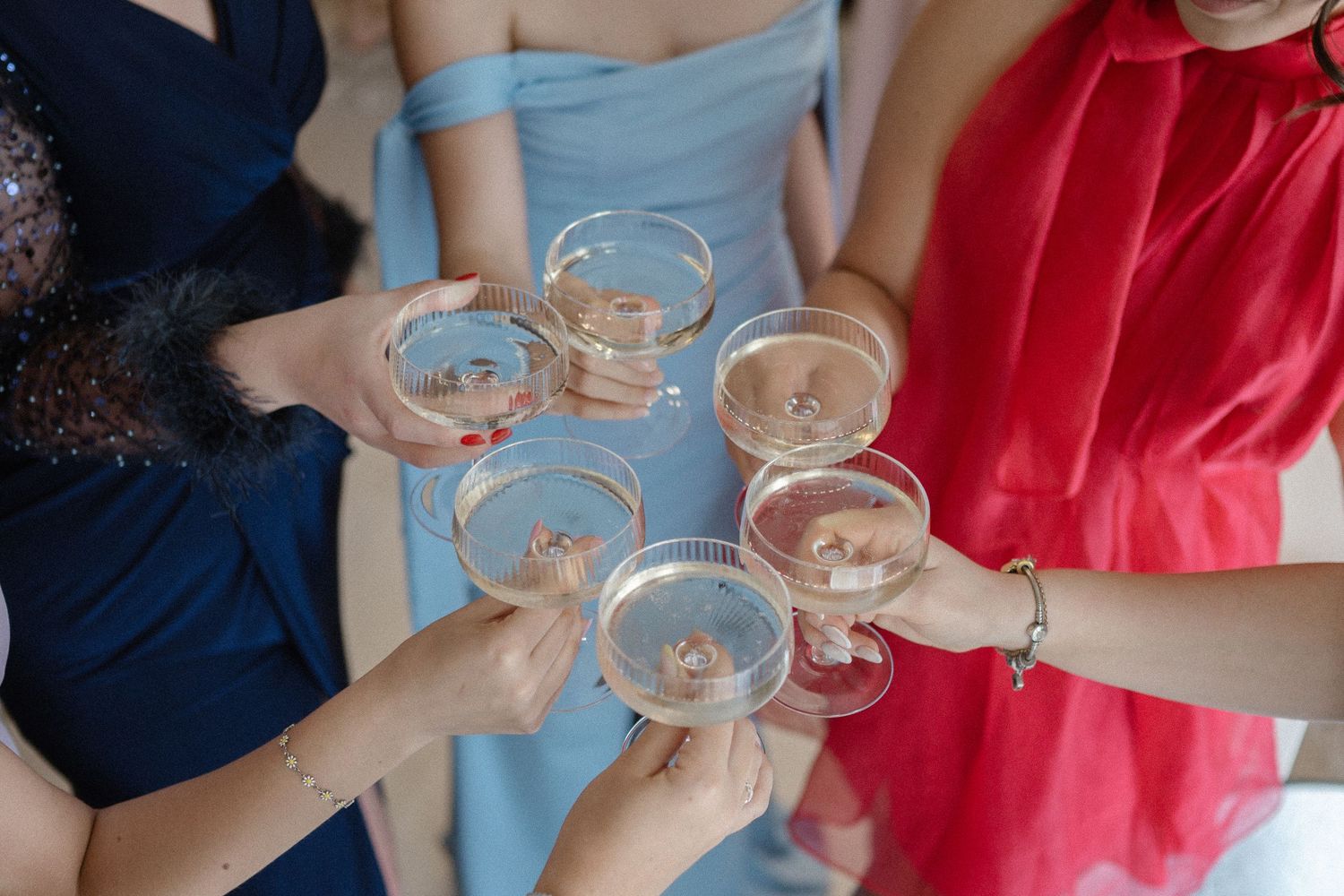 People in formal attire raise champagne glasses for a toast.
