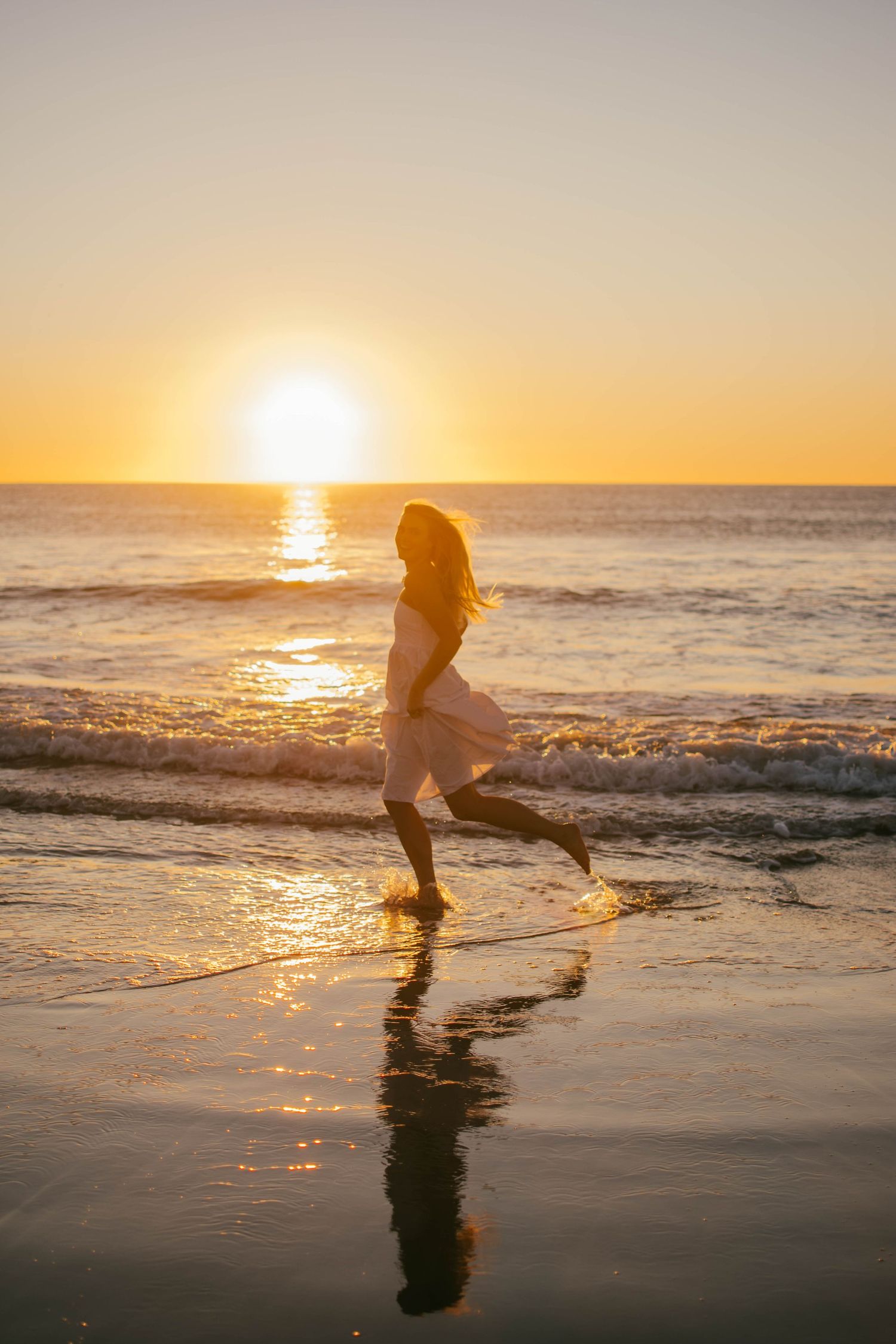 Artistic shots of someone splashing and playing in ocean waves at golden hour.