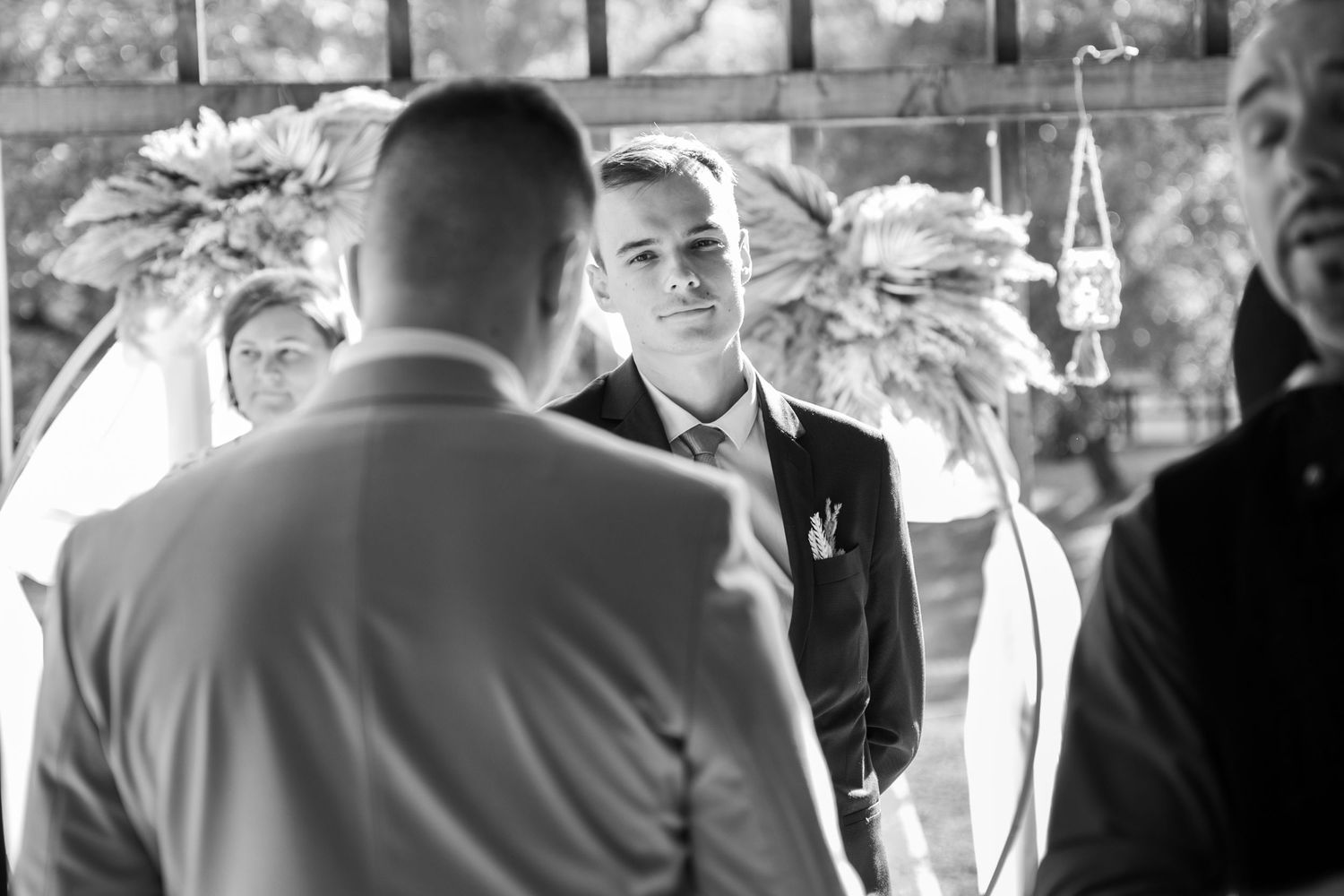 Wedding ceremony guests seated outdoors in natural lighting.