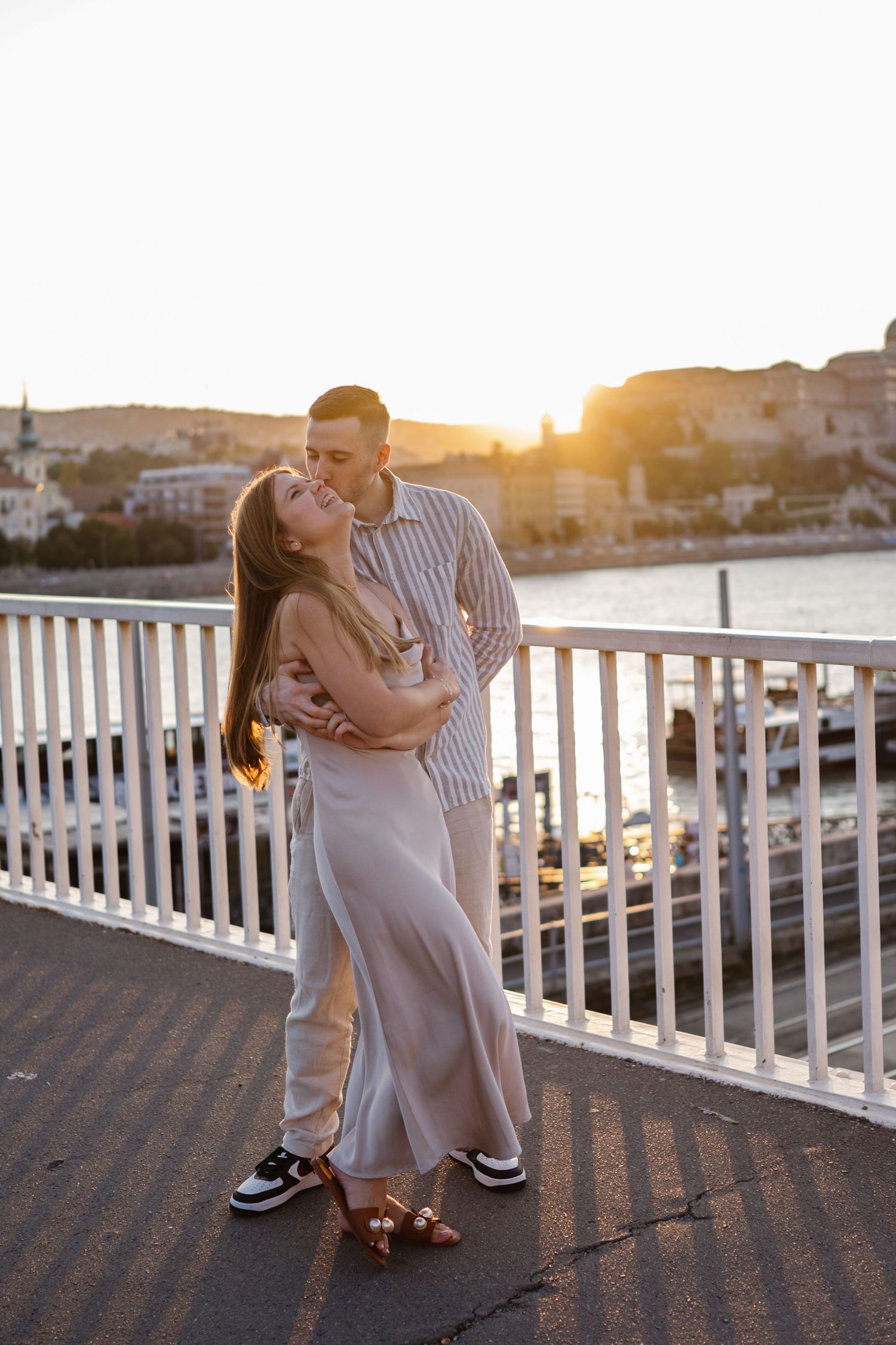 Romantic sunset moment on a waterfront deck with white railings.