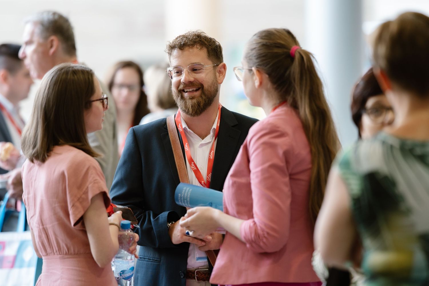 Conference attendees in business attire engaged in conversation during networking session.