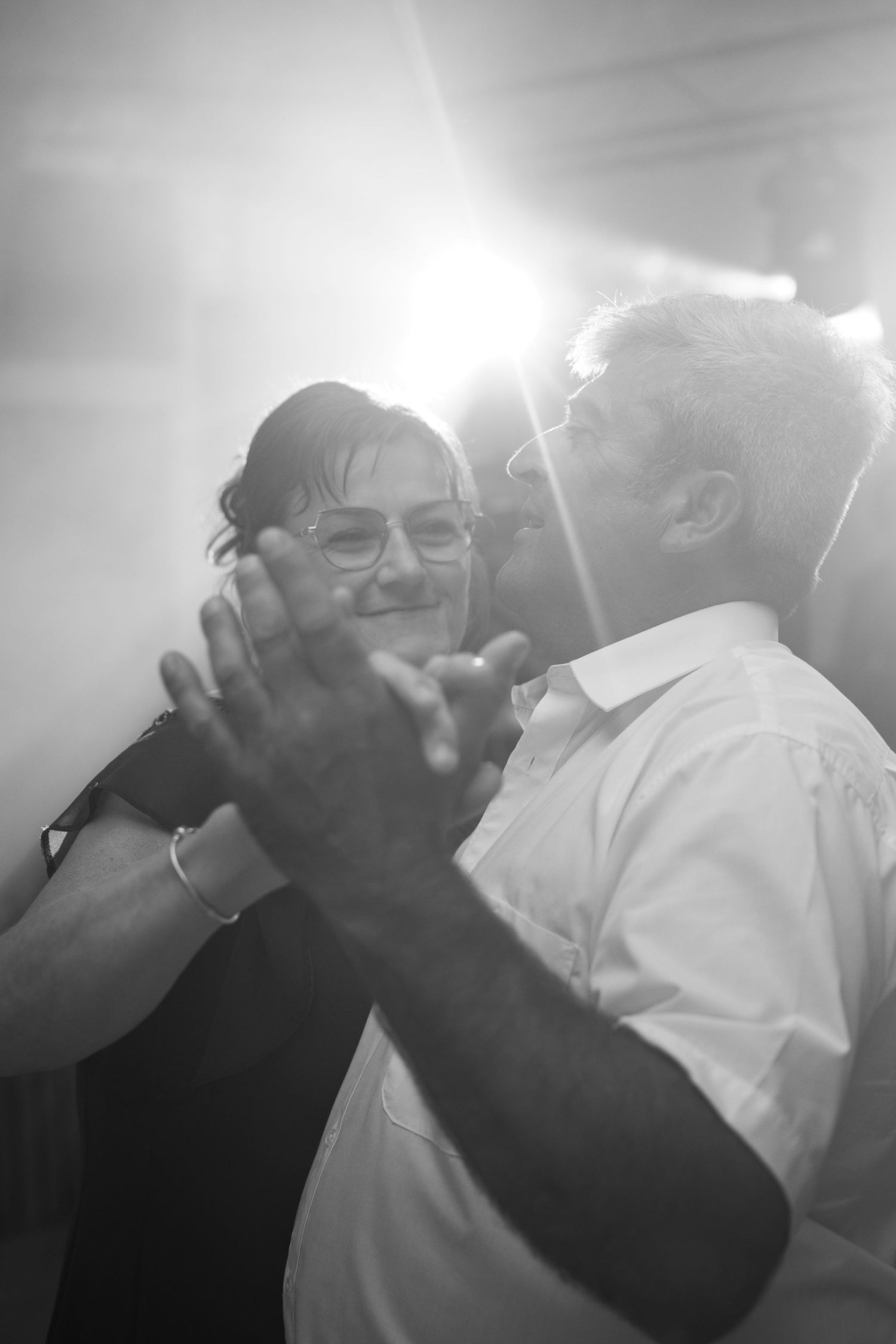 Black and white photo captures intimate dancing moment between wedding guests.