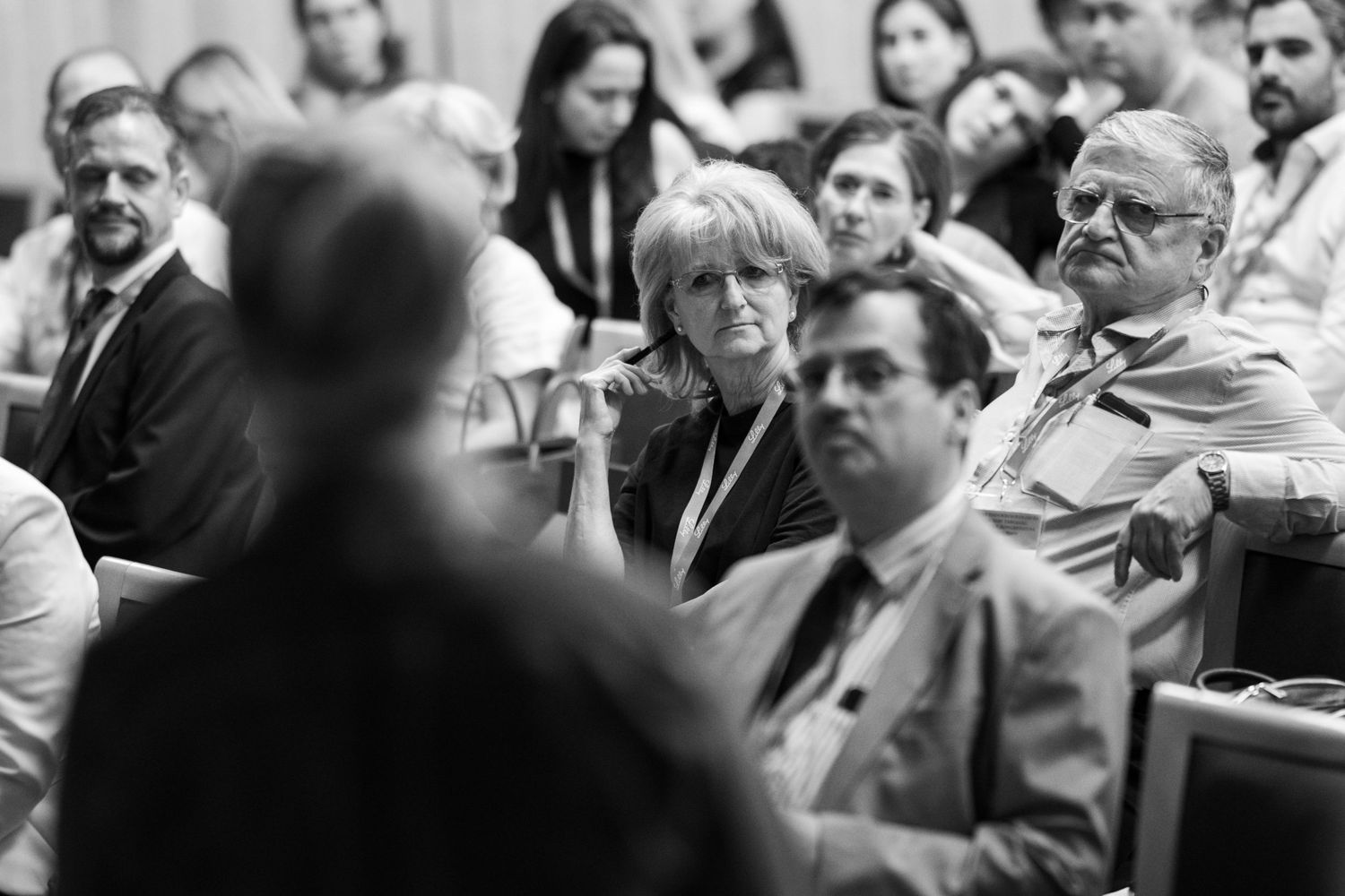 Black and white photo of attentive audience members seated in rows during a professional conference or lecture.
