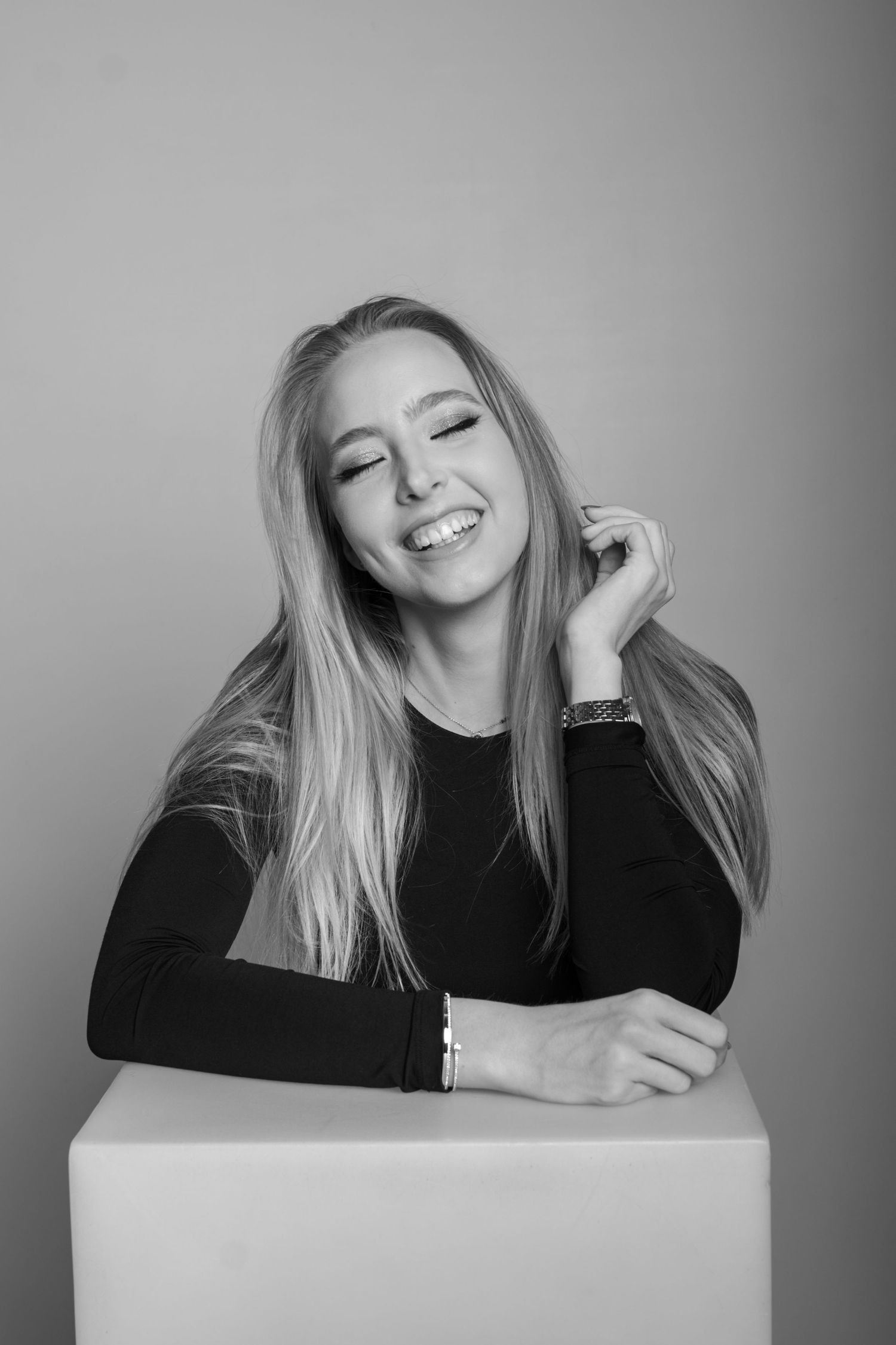 Black and white portrait series showing playful expressions and poses against light background.