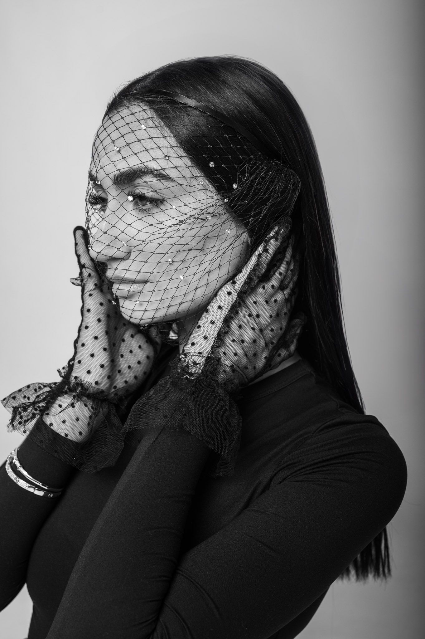 Artistic black and white portrait series with dramatic veil and dark clothing.