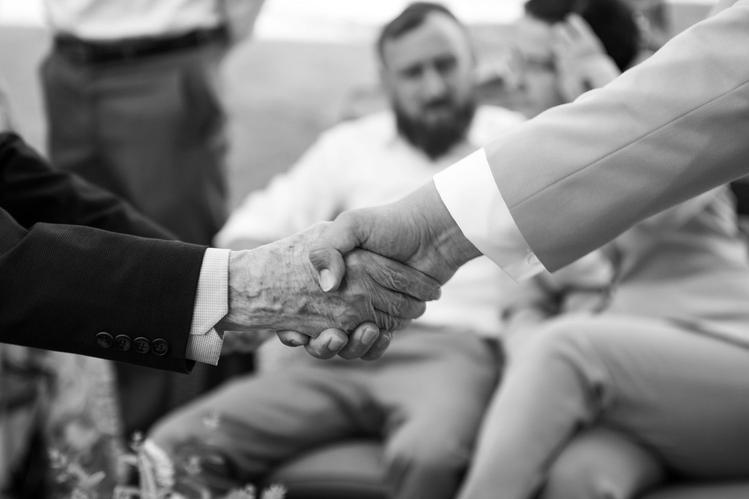 Close-up shot of hands exchanging business cards during a professional meeting.
