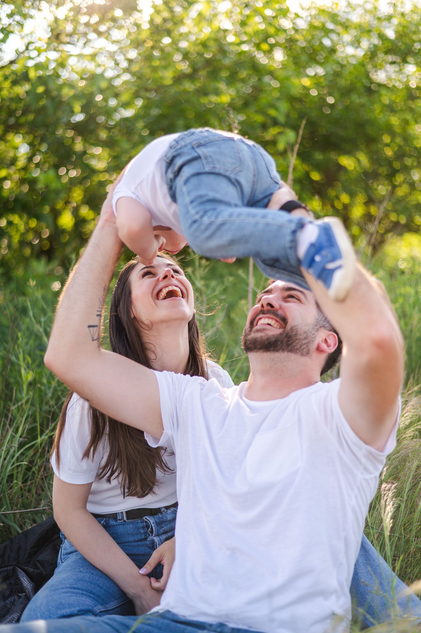 Joyful candid moments captured of people laughing together in a grassy summer field.