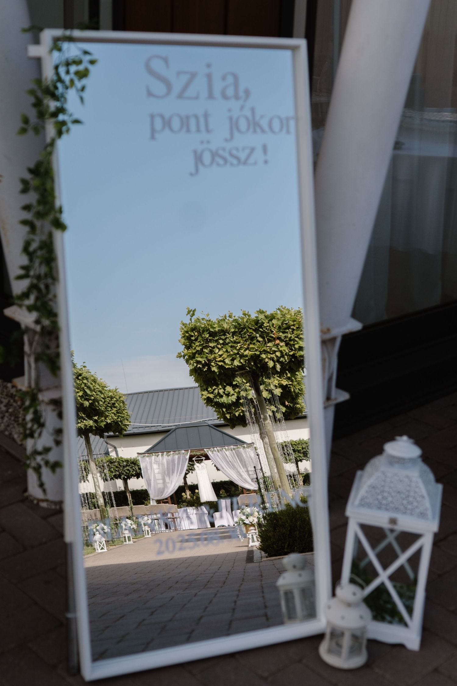 White-framed mirror and lantern decorations at an outdoor wedding venue.