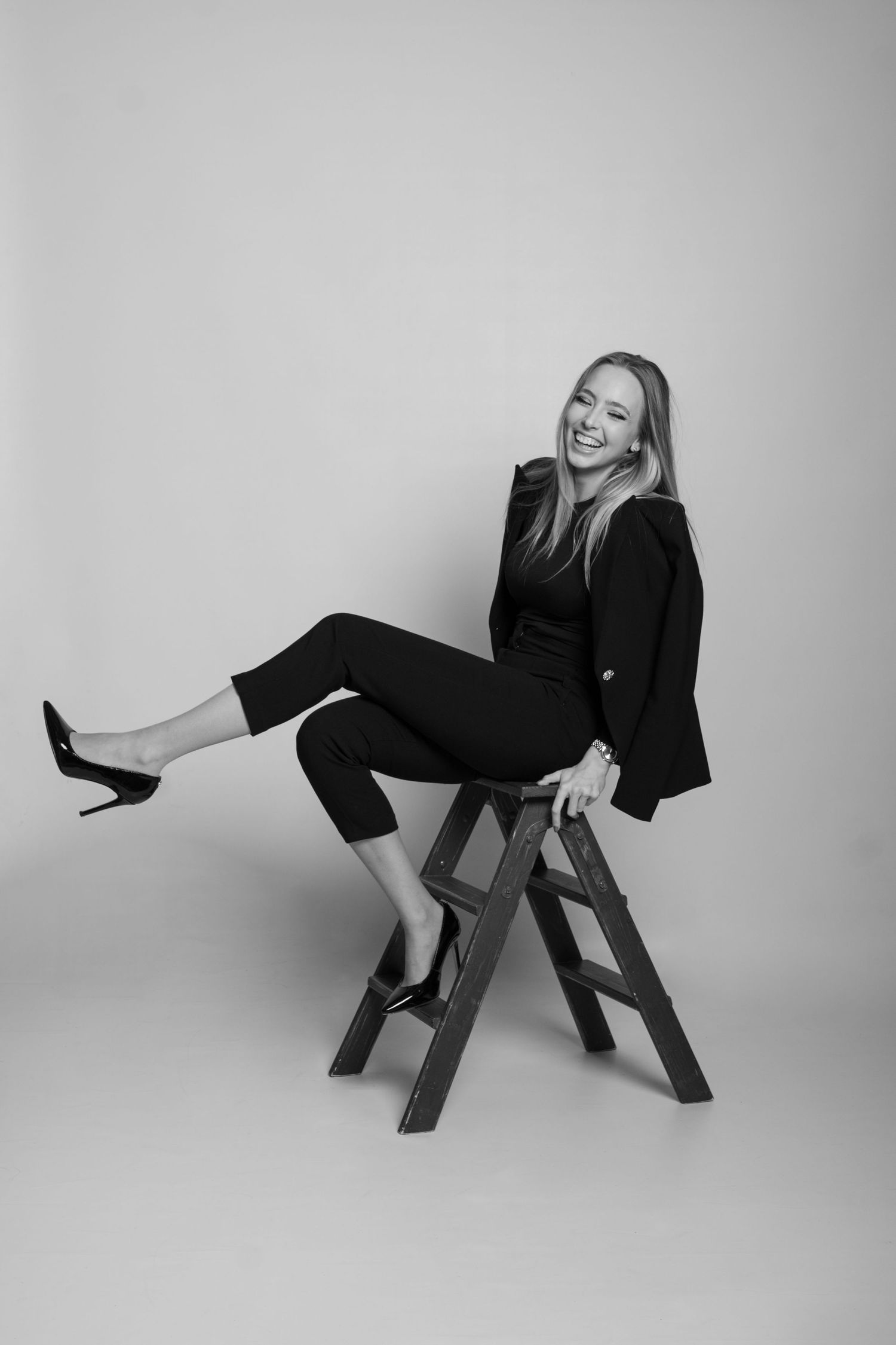 Black and white fashion series featuring dynamic poses on a wooden bench.