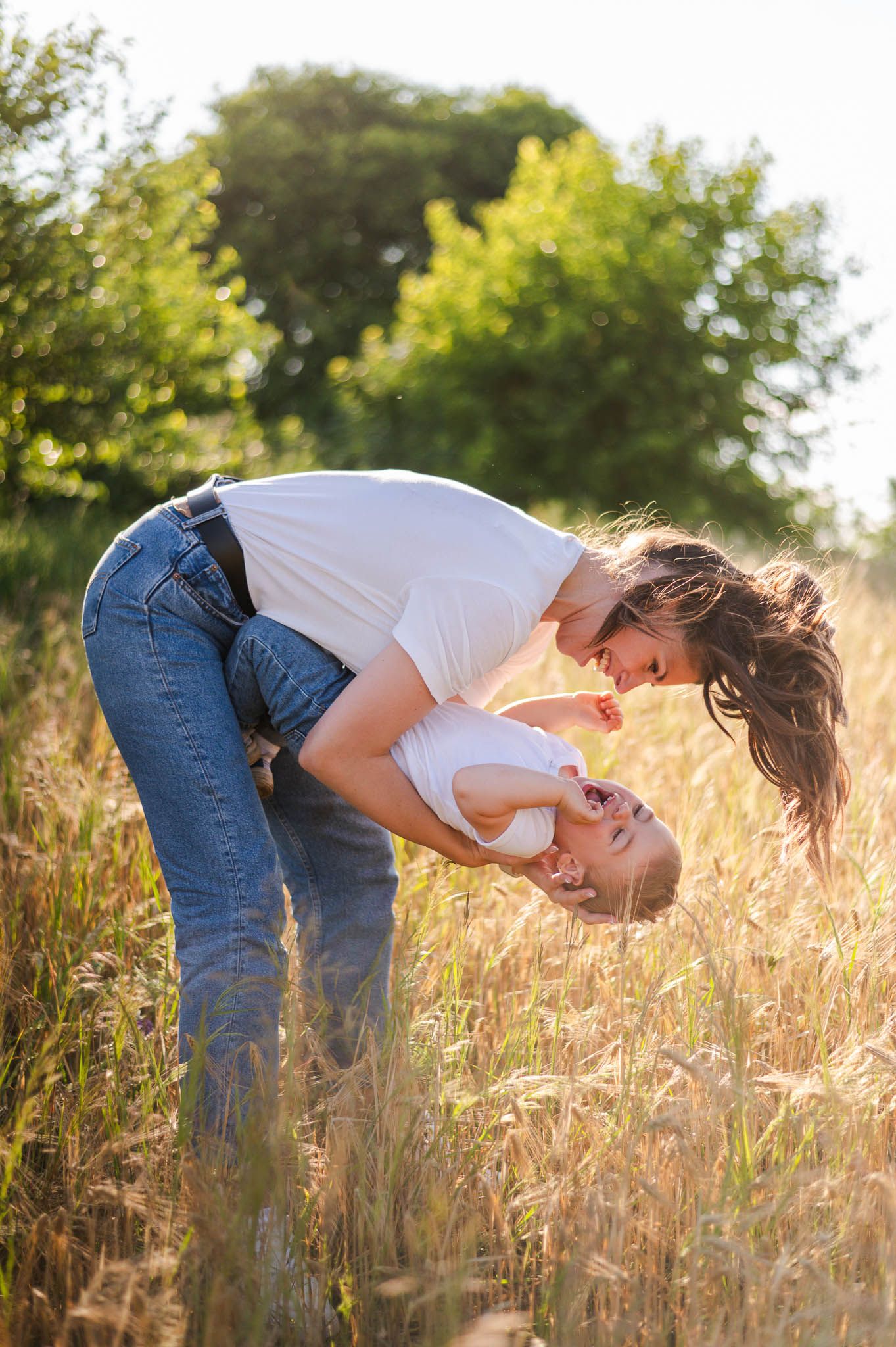 Playful sequence of someone bending down in a golden wheat field at sunset.