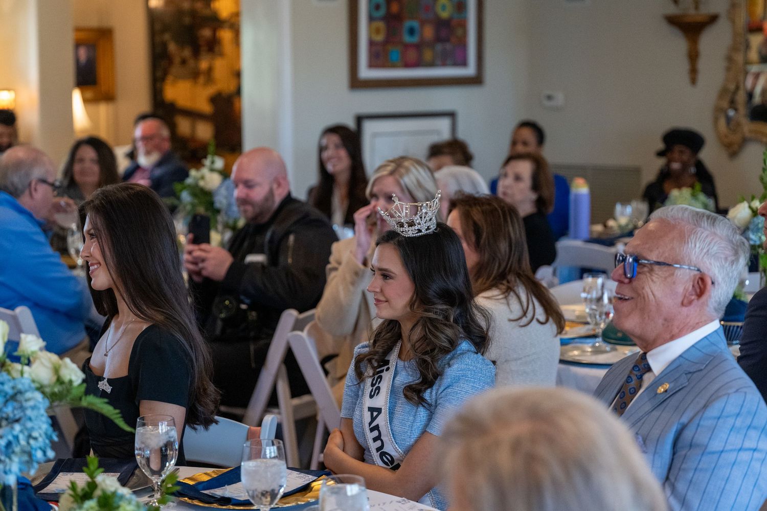 Miss America's Teen listens to a speaker at a luncheon event.
