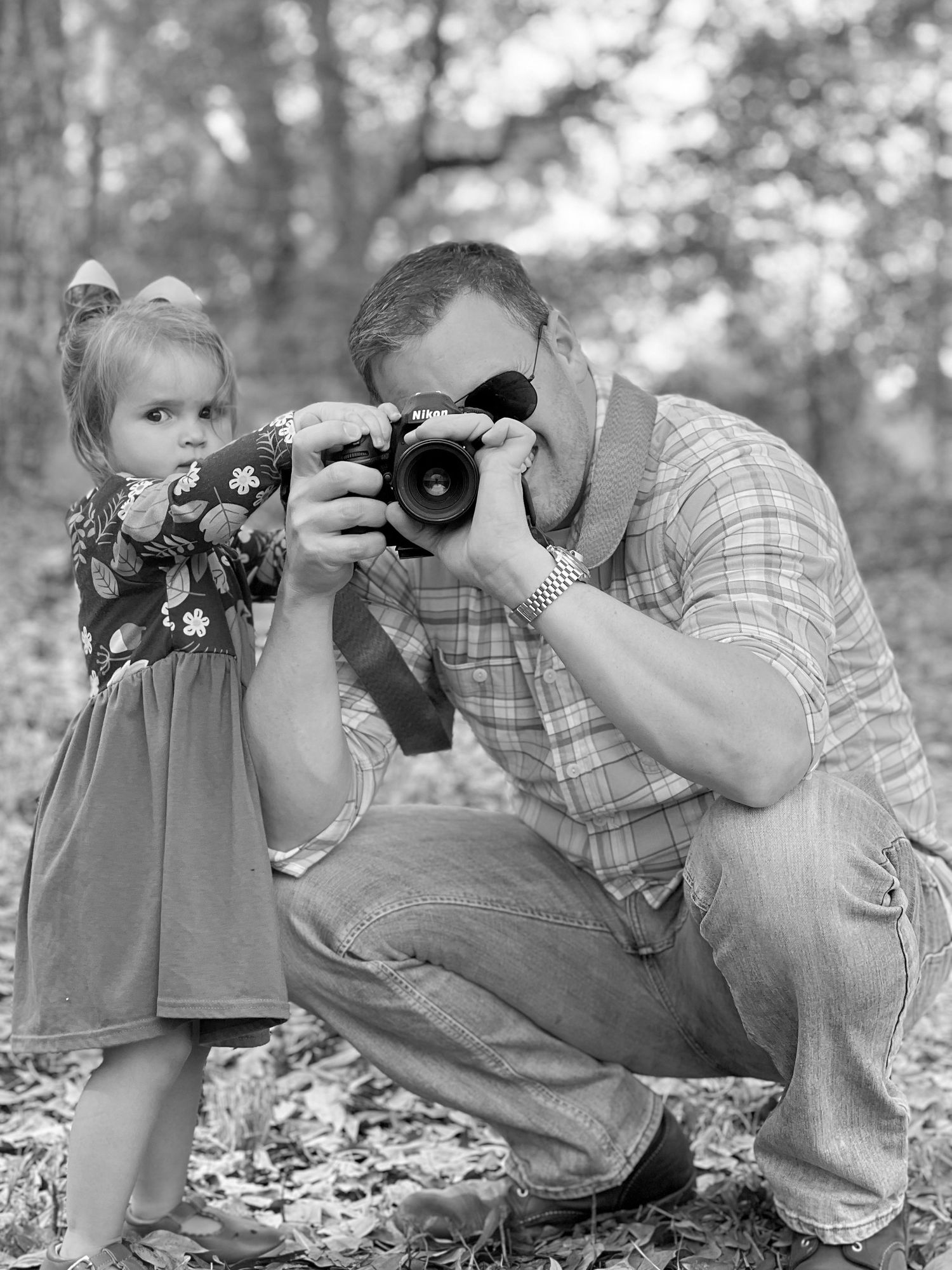 Black and white photo of a photographer and small child.