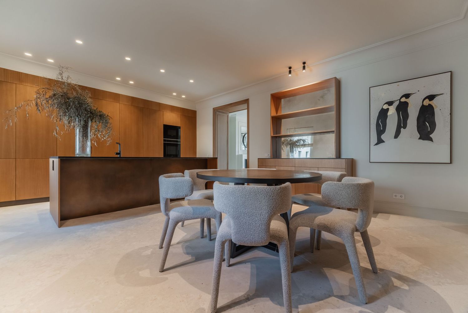 comedor moderno con mesa central, sillas tapizadas y mobiliario de madera