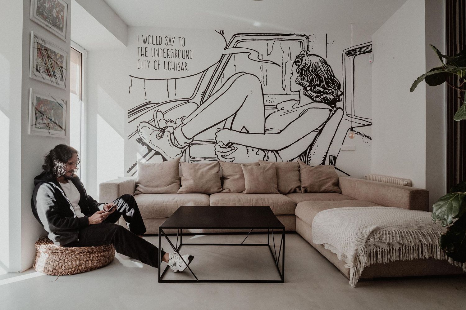Interior de vivienda moderna con sofá beige y mural artístico en pared