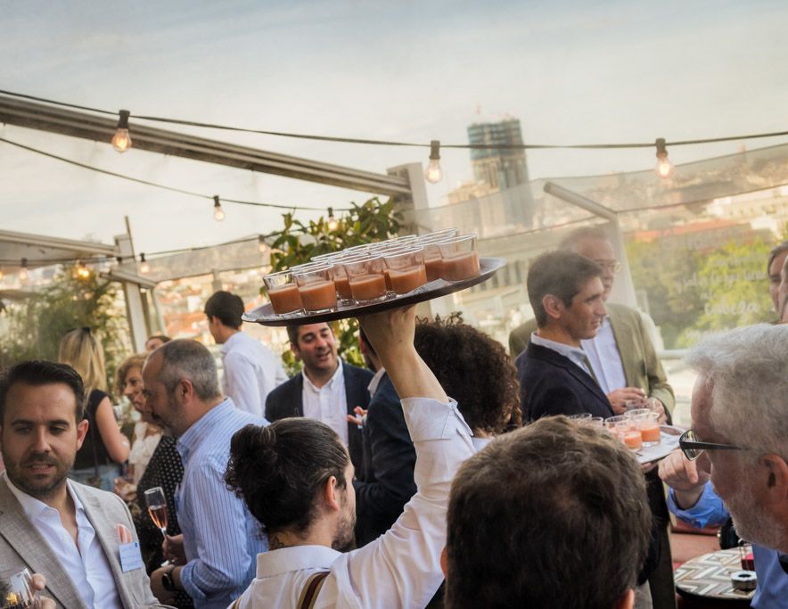 camarero sirviendo salmorejo a los invitados de un evento corporativo en una terraza