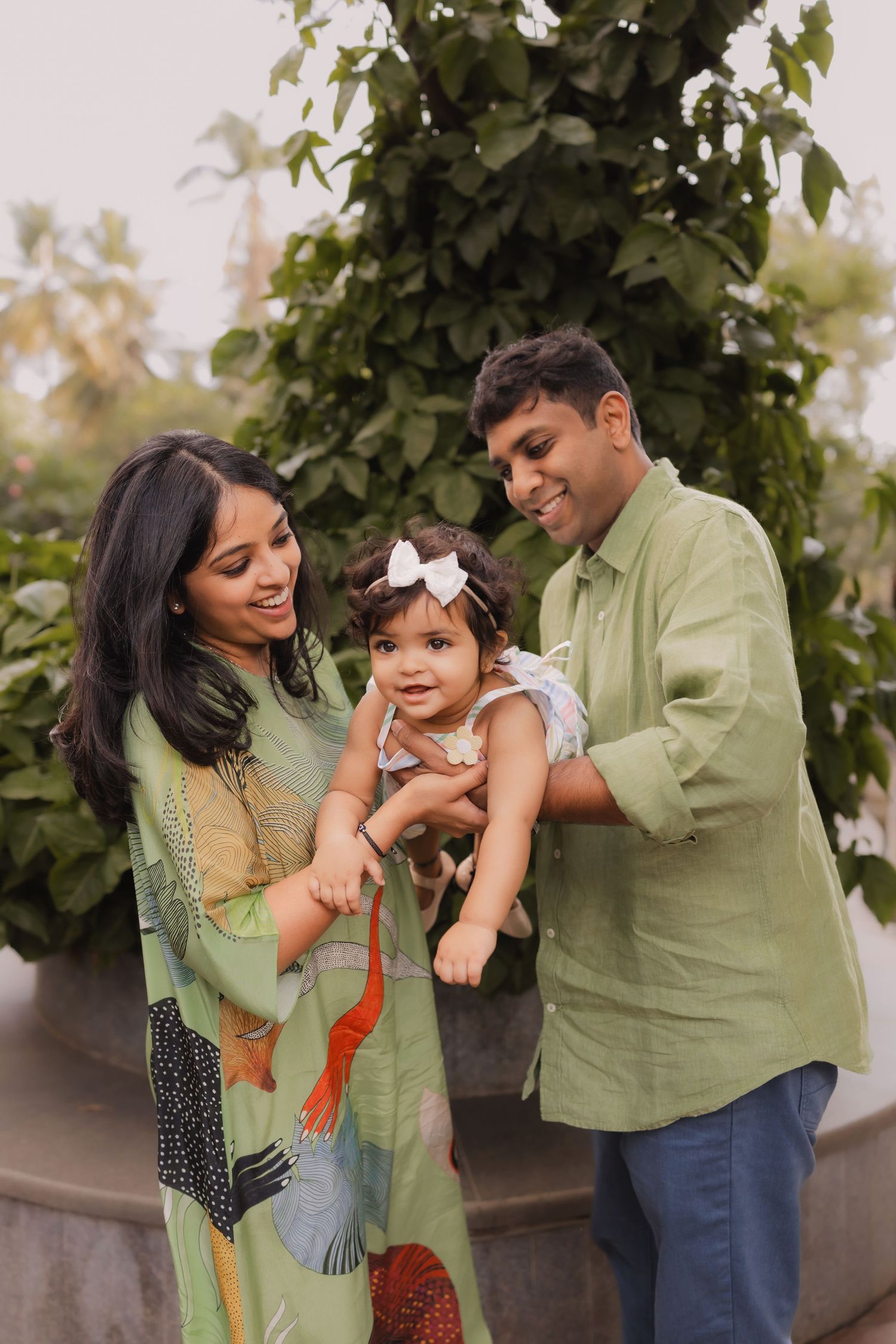 A family shares a tender moment together in an outdoor garden setting.