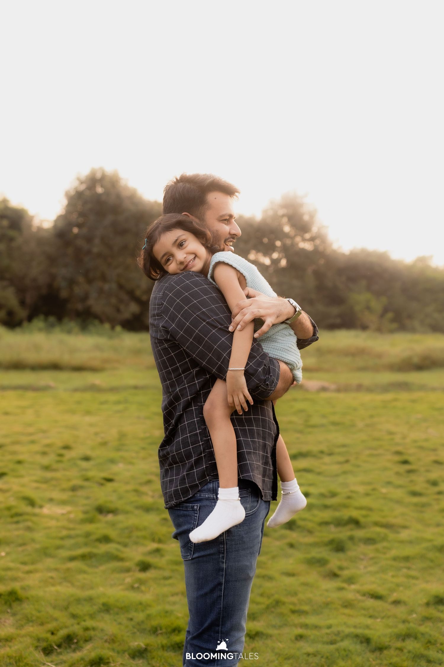Sweet outdoor portrait in a grassy field during golden hour.