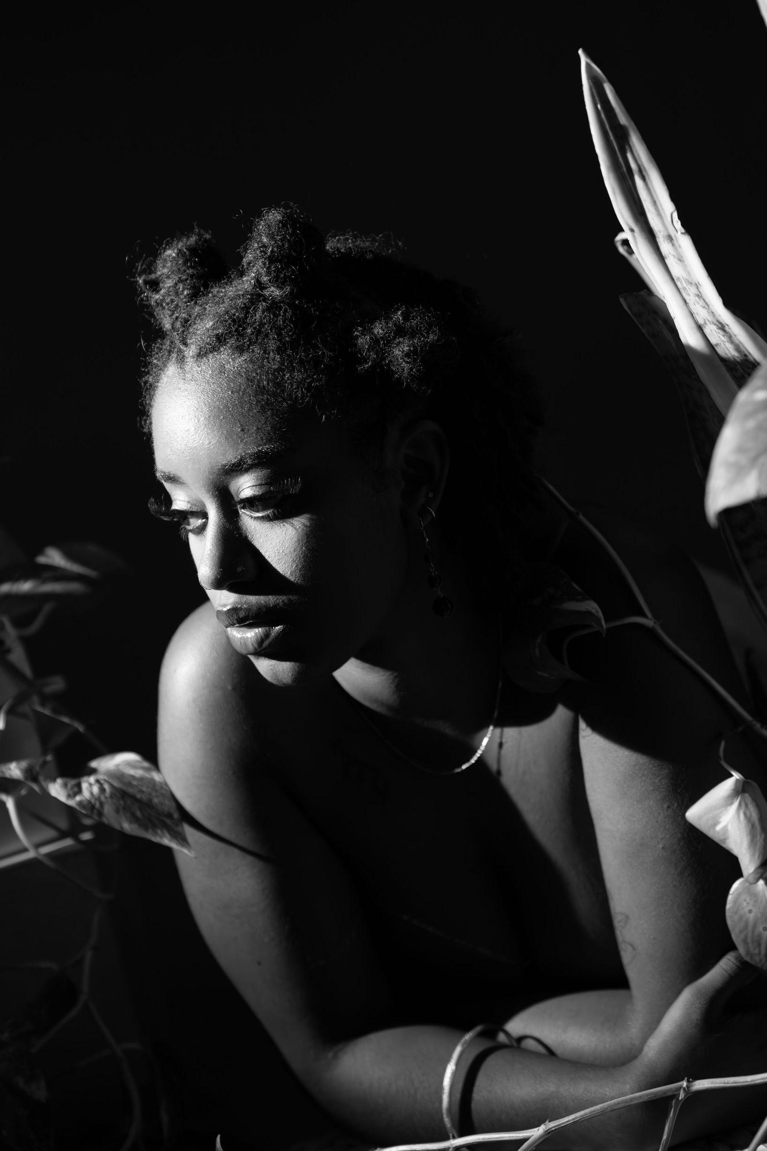 Artistic black and white boudoir photography with dramatic shadows and lighting.