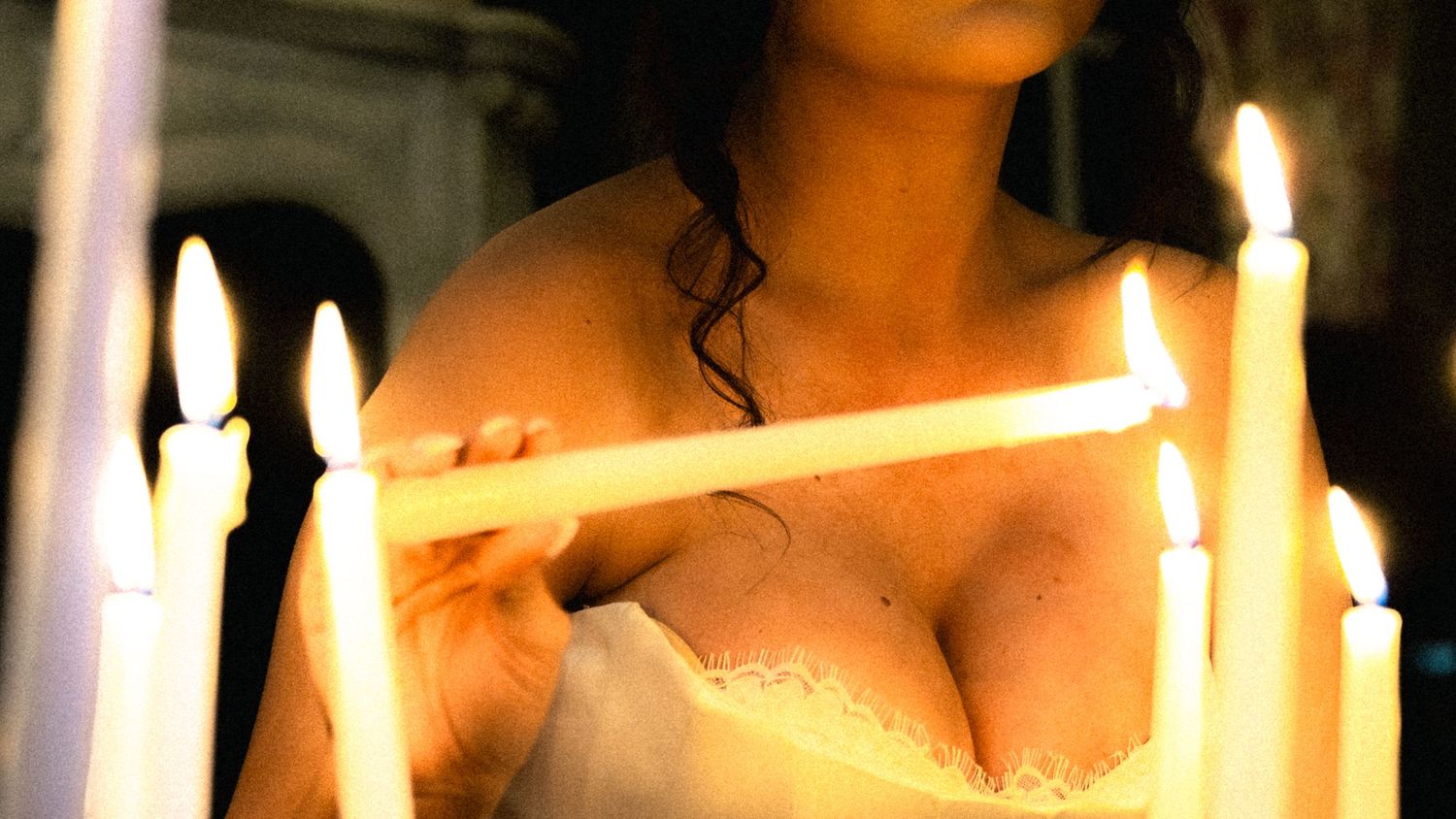 A candlelit scene creates a romantic atmosphere with warm glowing light and shadows.