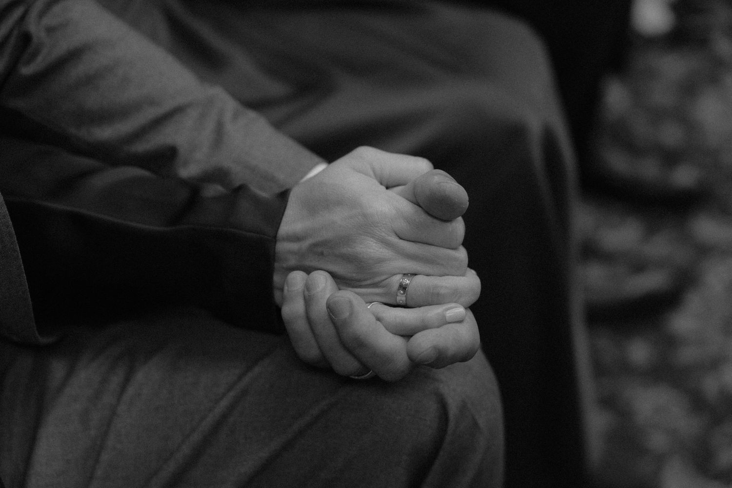 Close-up shots of hands clasped together in various poses showing wedding rings and formal attire.