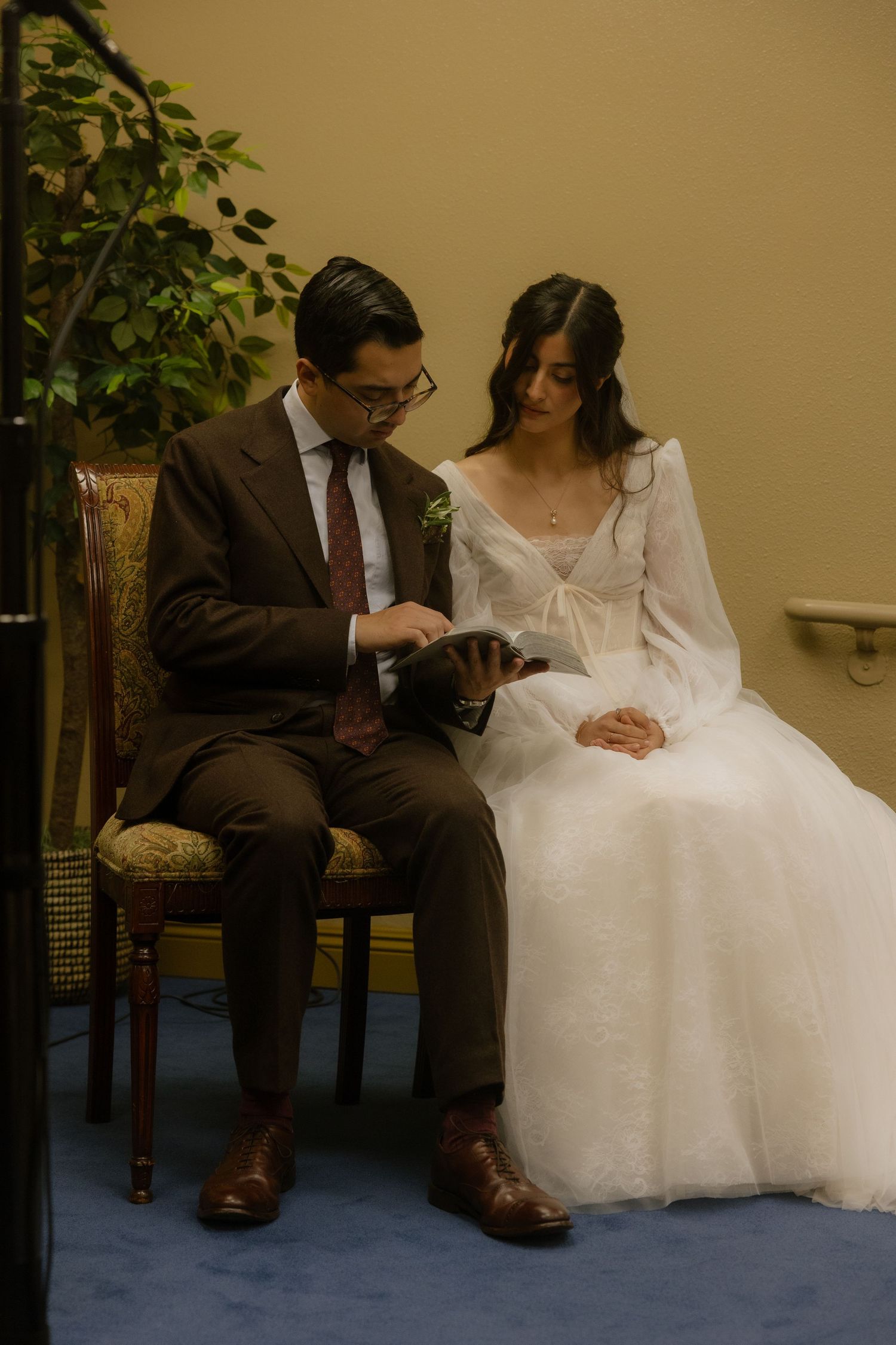 Couple sitting together on chairs having an intimate moment before their wedding ceremony.