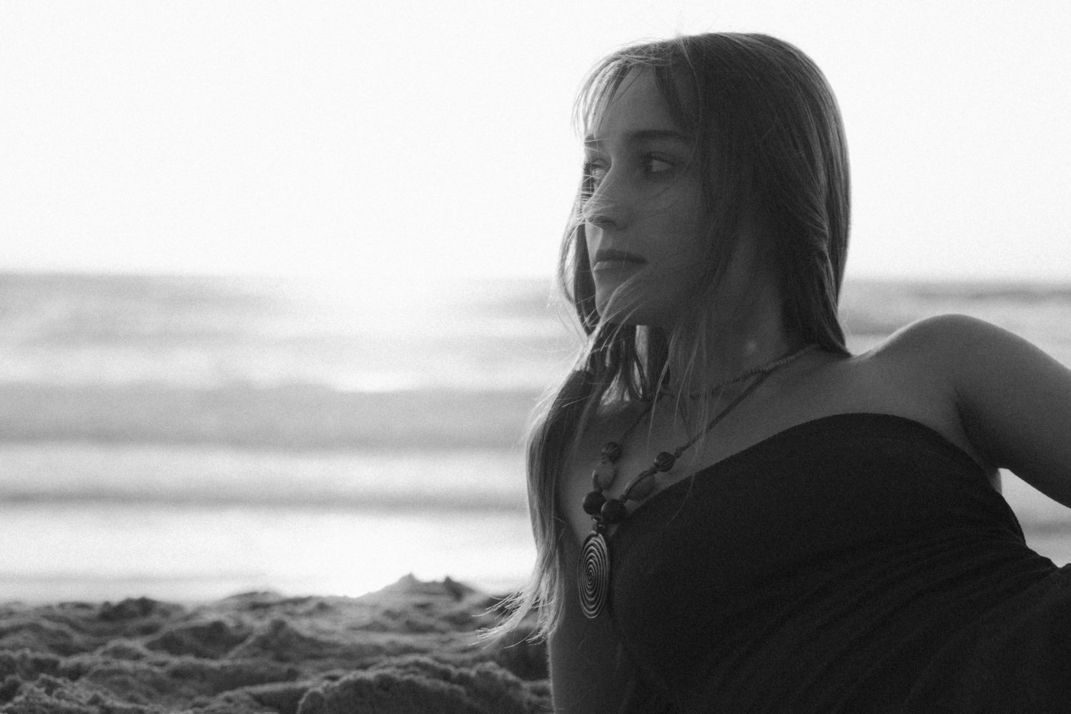 A black and white montage of five intimate moments captured at sunset on a beach.