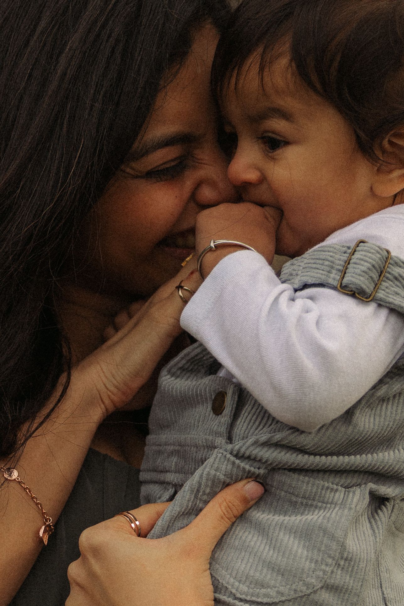 A tender moment captured in a sequence showing loving kisses and embraces between parent and baby in soft lighting.