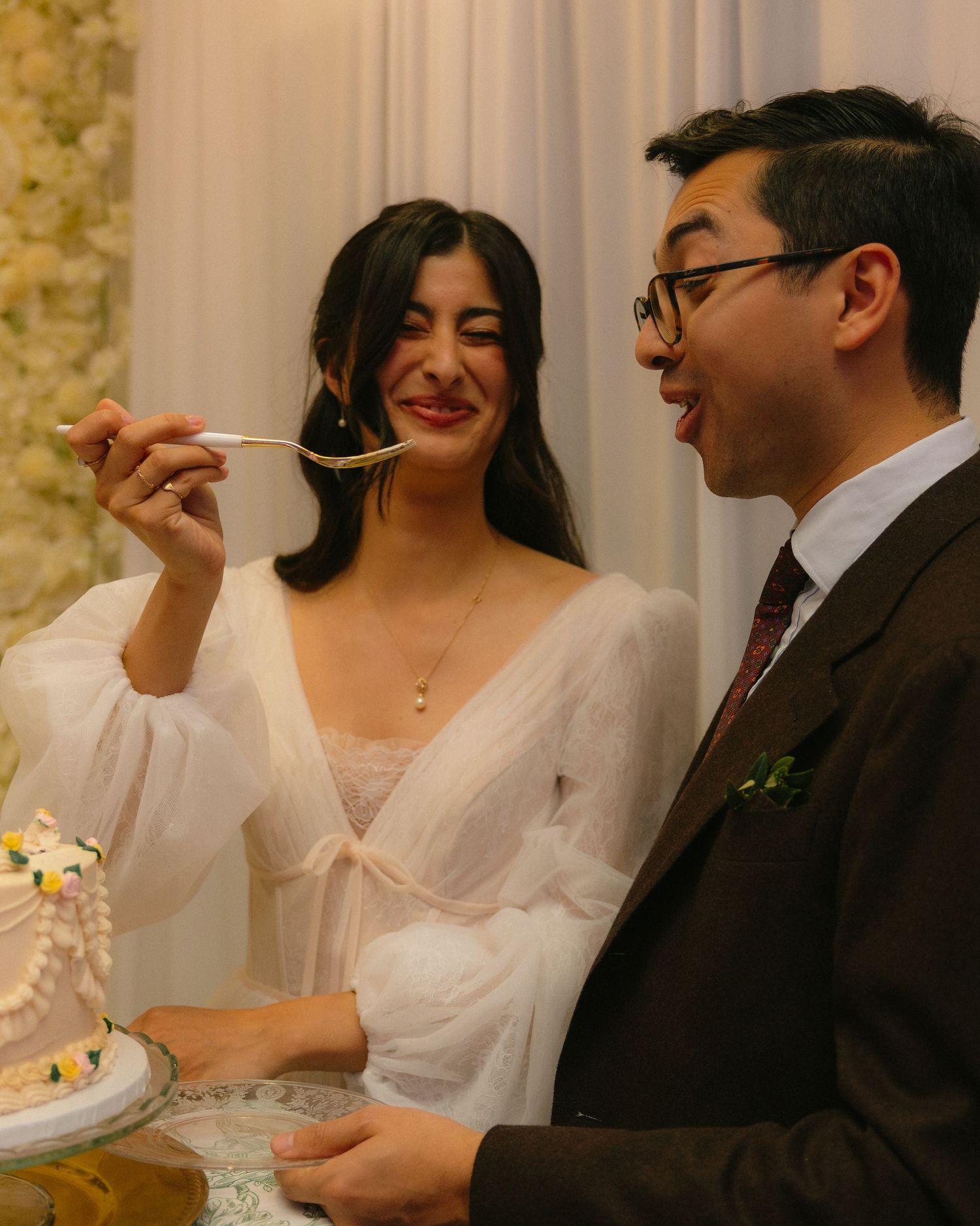 Wedding reception celebration with guests seated at a decorated head table with white linens and candles.