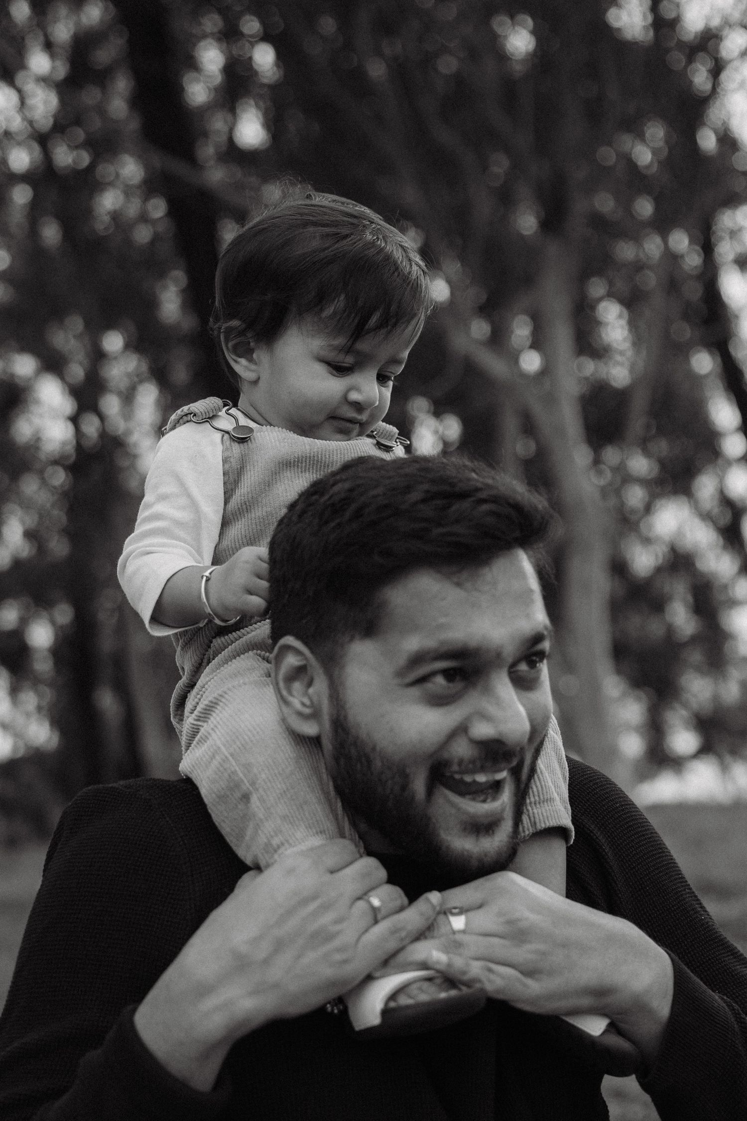 A heartwarming black and white sequence shows a playful interaction between a parent and child in a park setting.